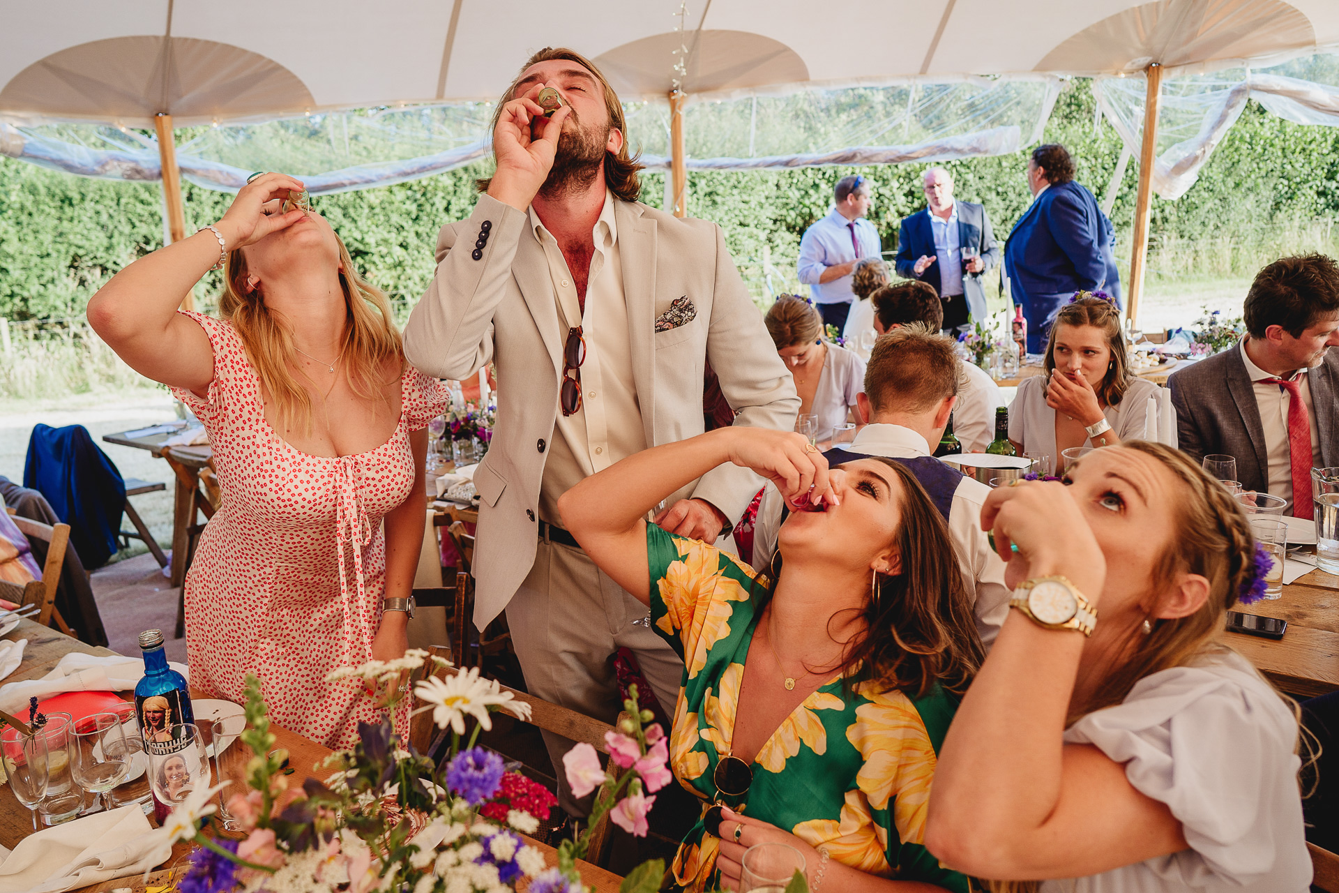Group of wedding guests downing shots