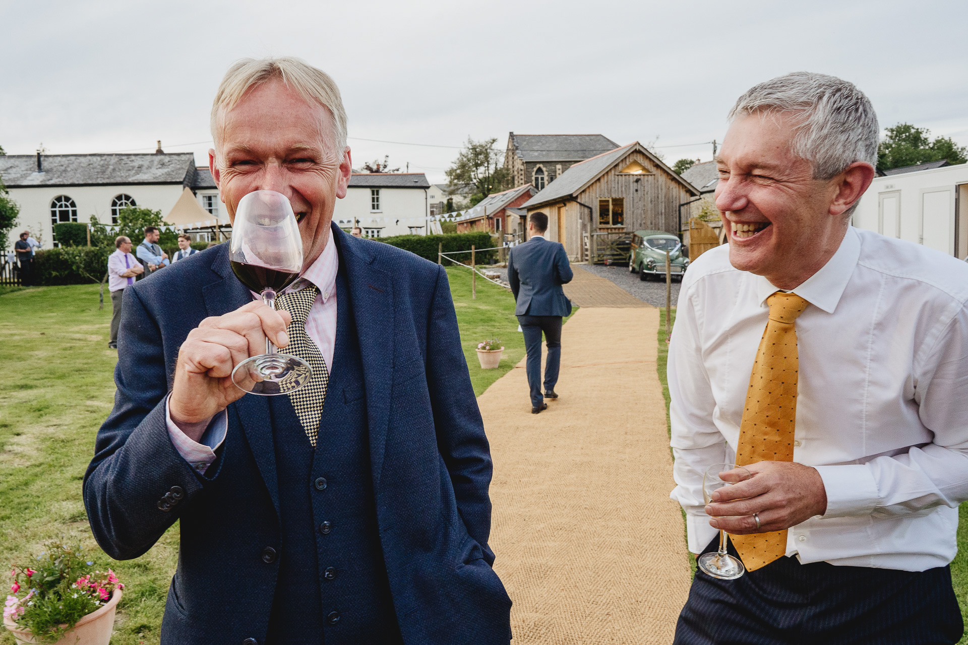 Two men laughing with a glass of wine