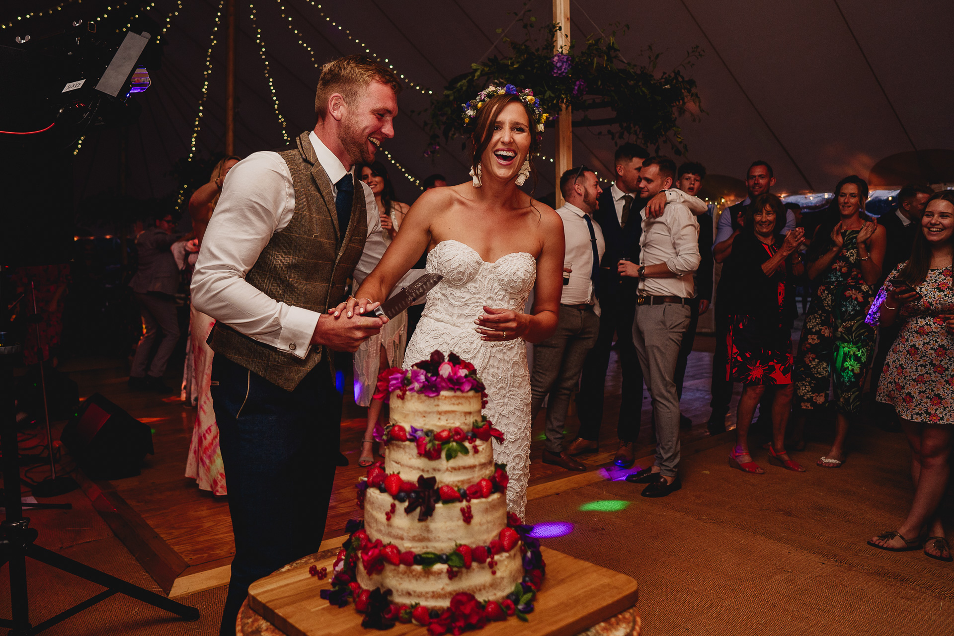 Bride and groom laughing cutting cake