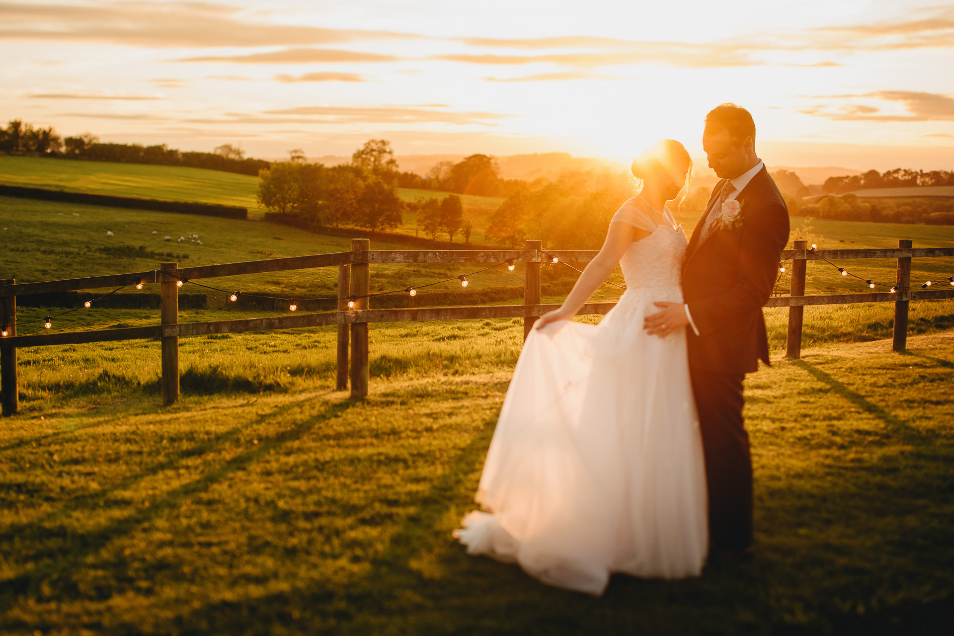 Bride and groom with sunset and countryside behind