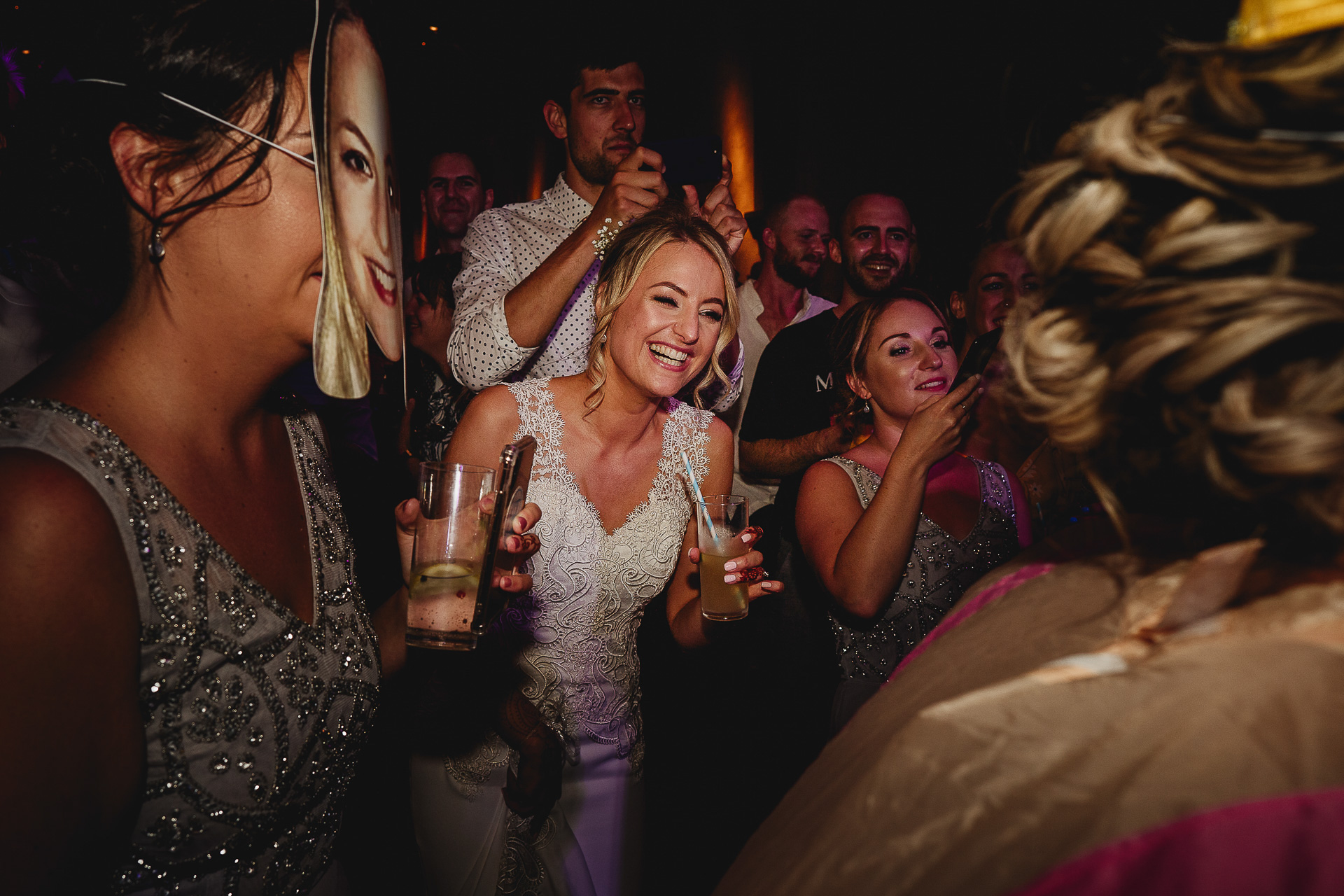 Bride laughing amongst other people on the dance floor