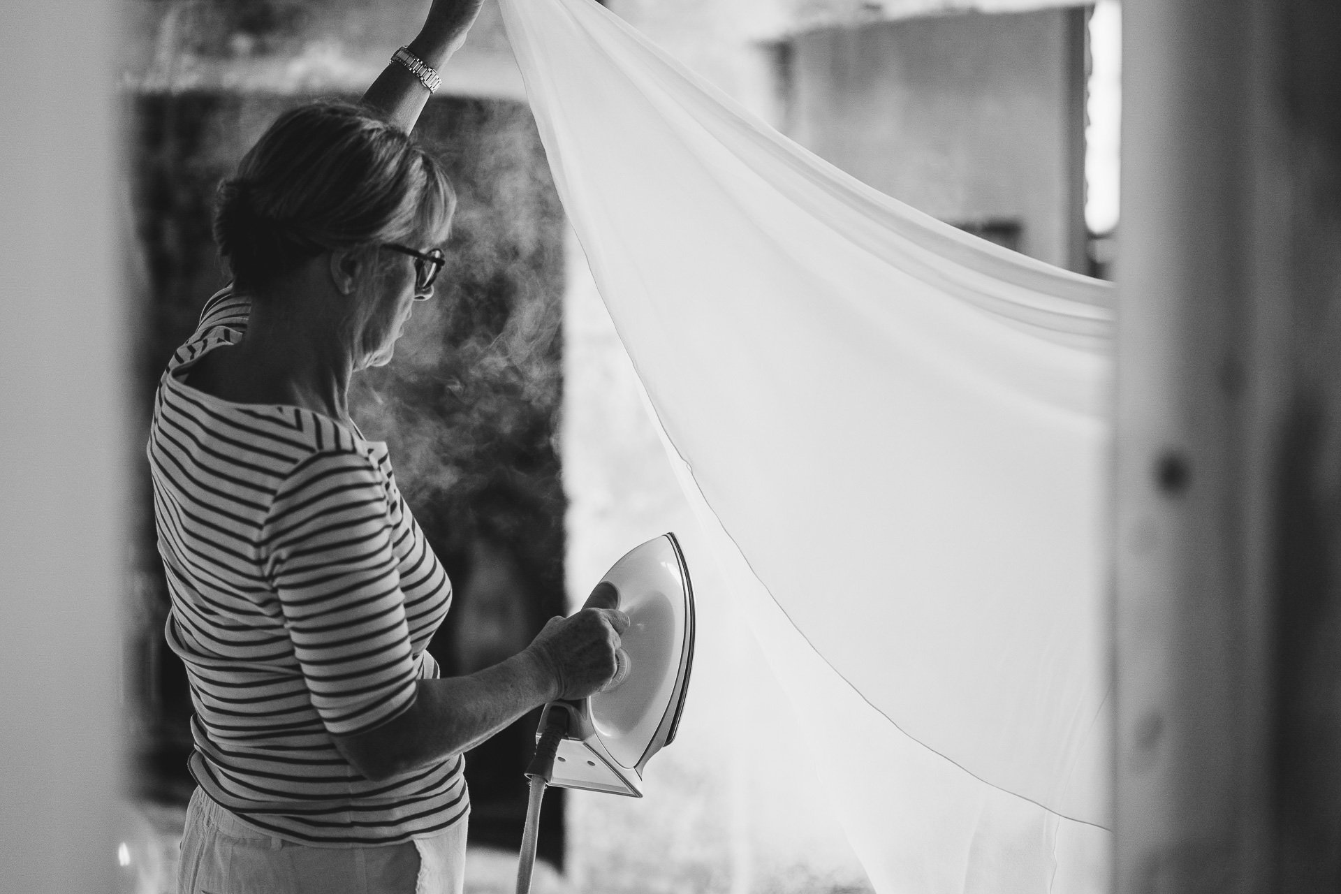 A woman steaming a wedding dress