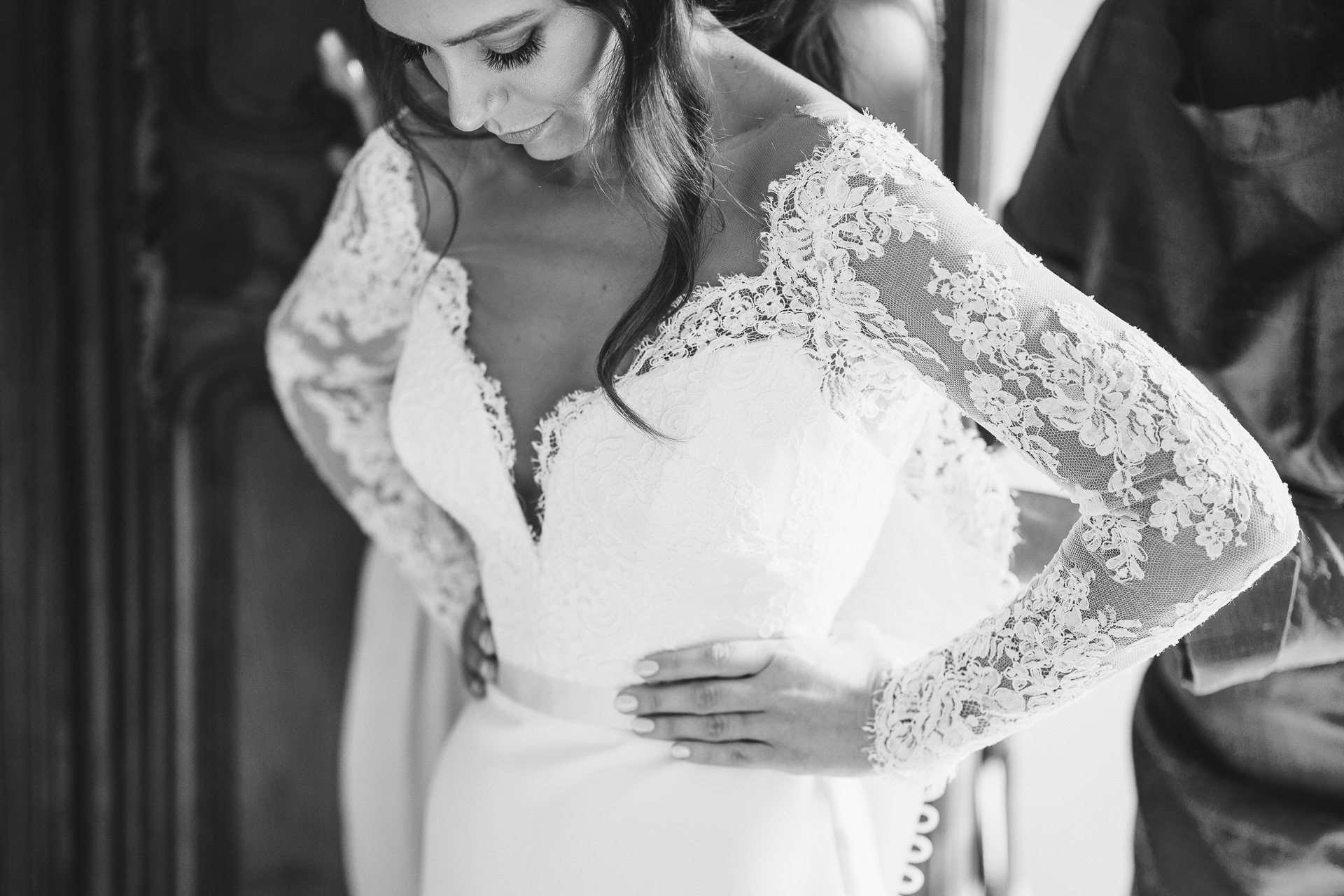 Bride putting on a lace wedding dress