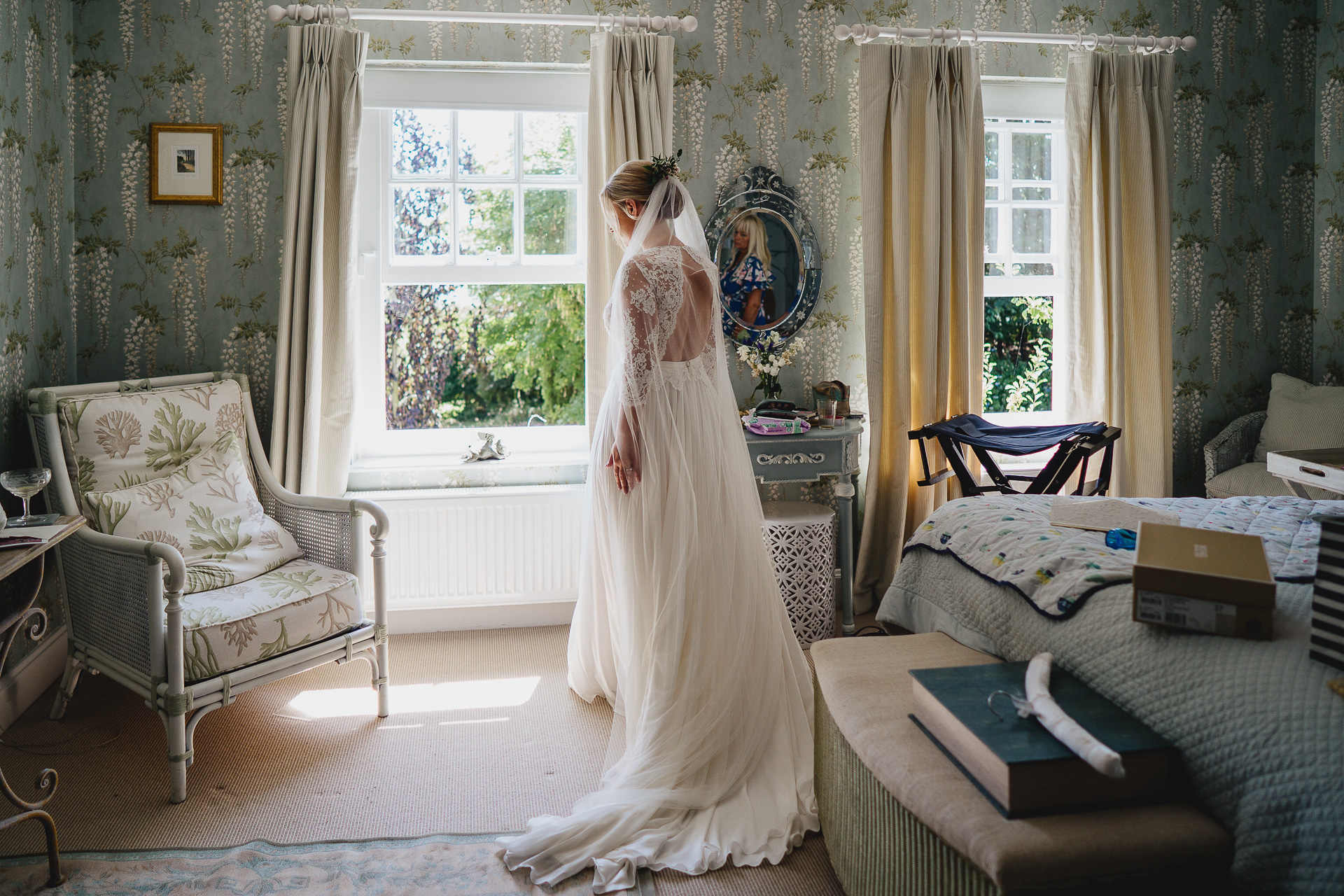 Bride in her wedding dress by a window