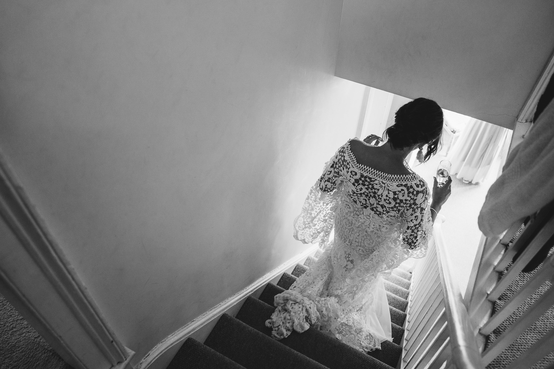 Bride in crocheted wedding dress going down stairs
