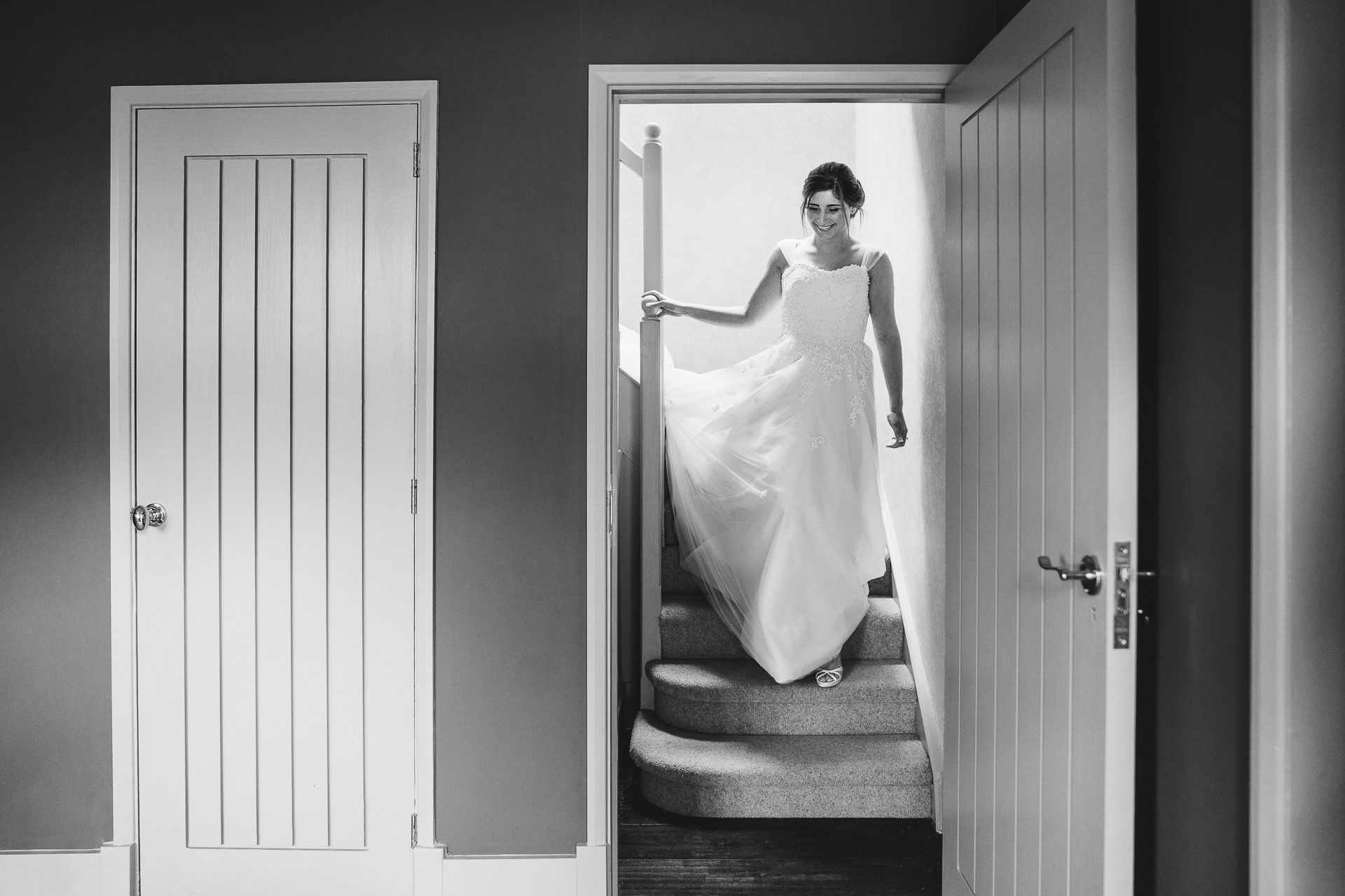 Bride coming down a staircase in wedding dress