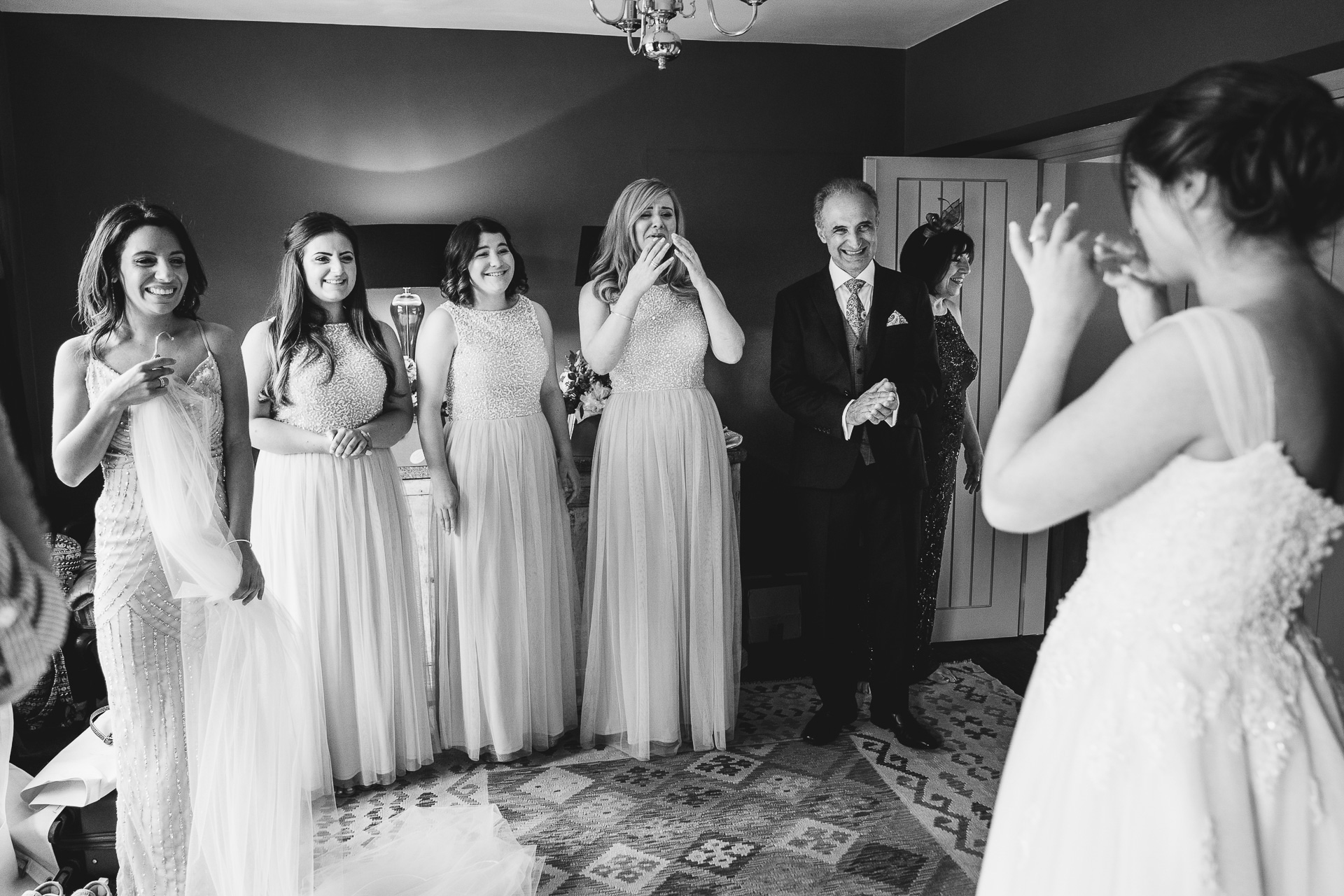 Group of people reacting to bride in wedding dress