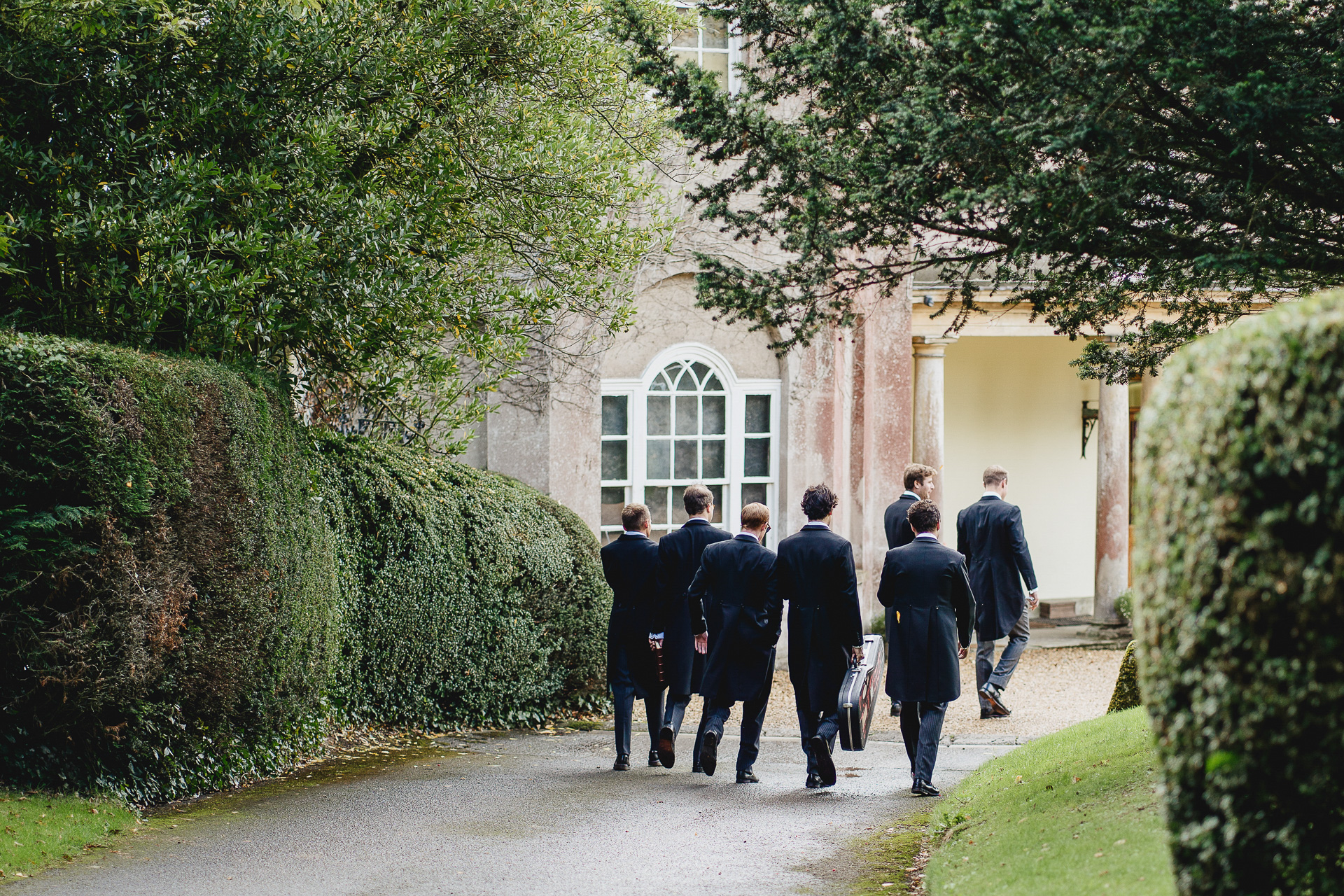 Group of groomsmen walking towards Pennard House