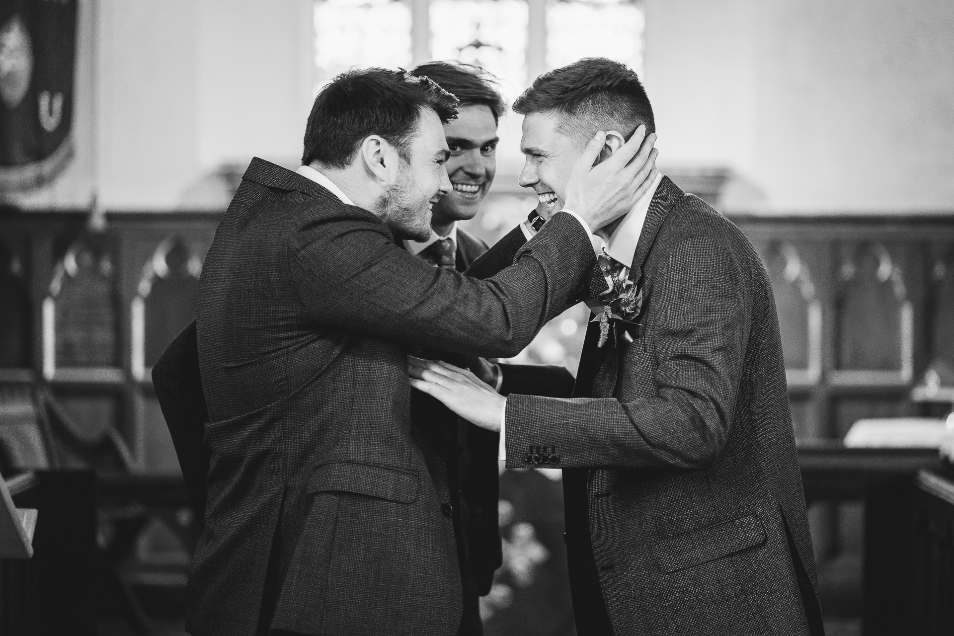 Groomsmen laughing together in a church