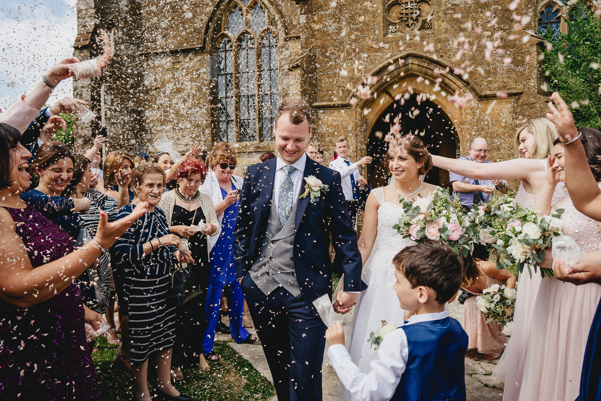 Bride and groom leaving church in a cloud of confetti