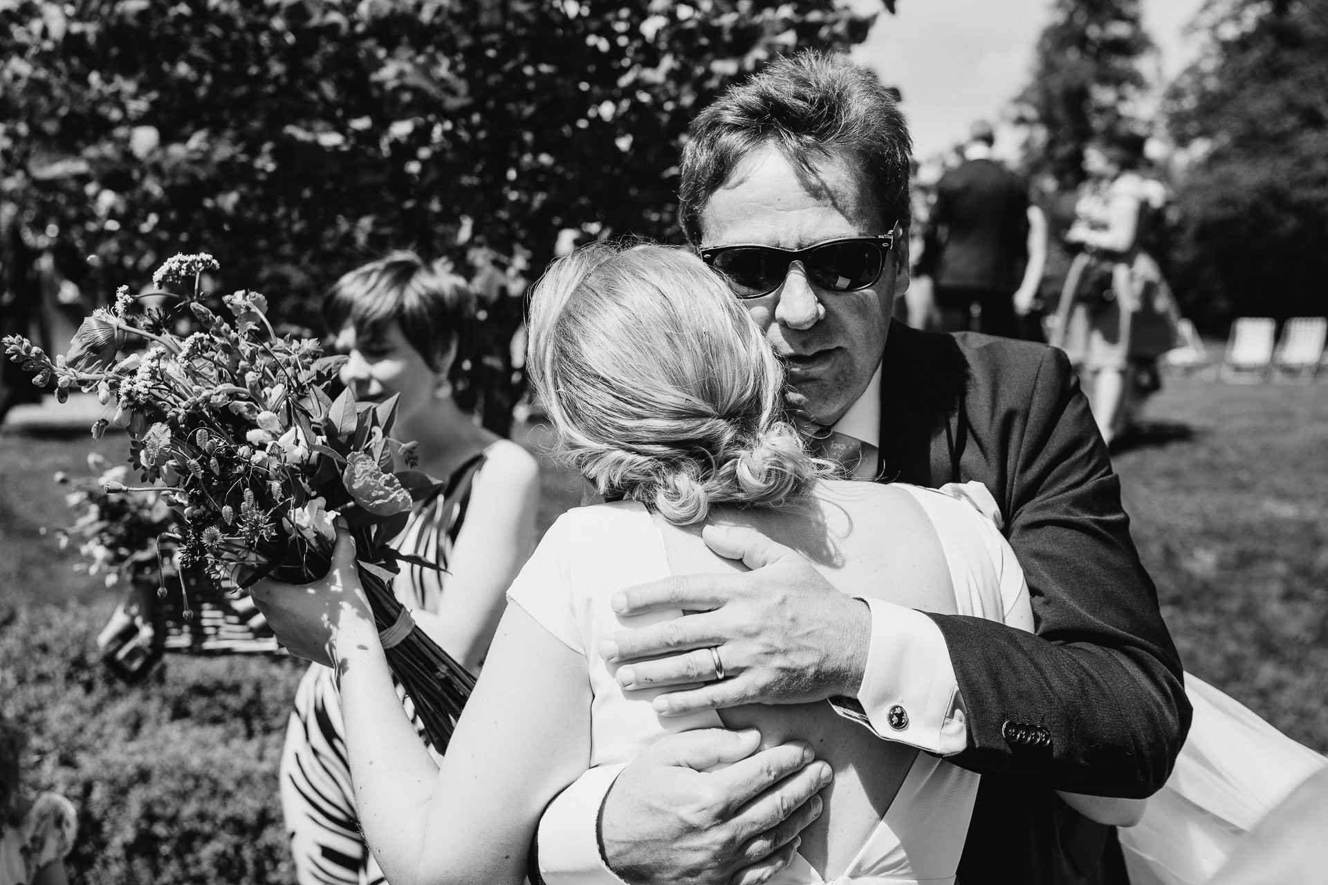 Father hugging bride after wedding