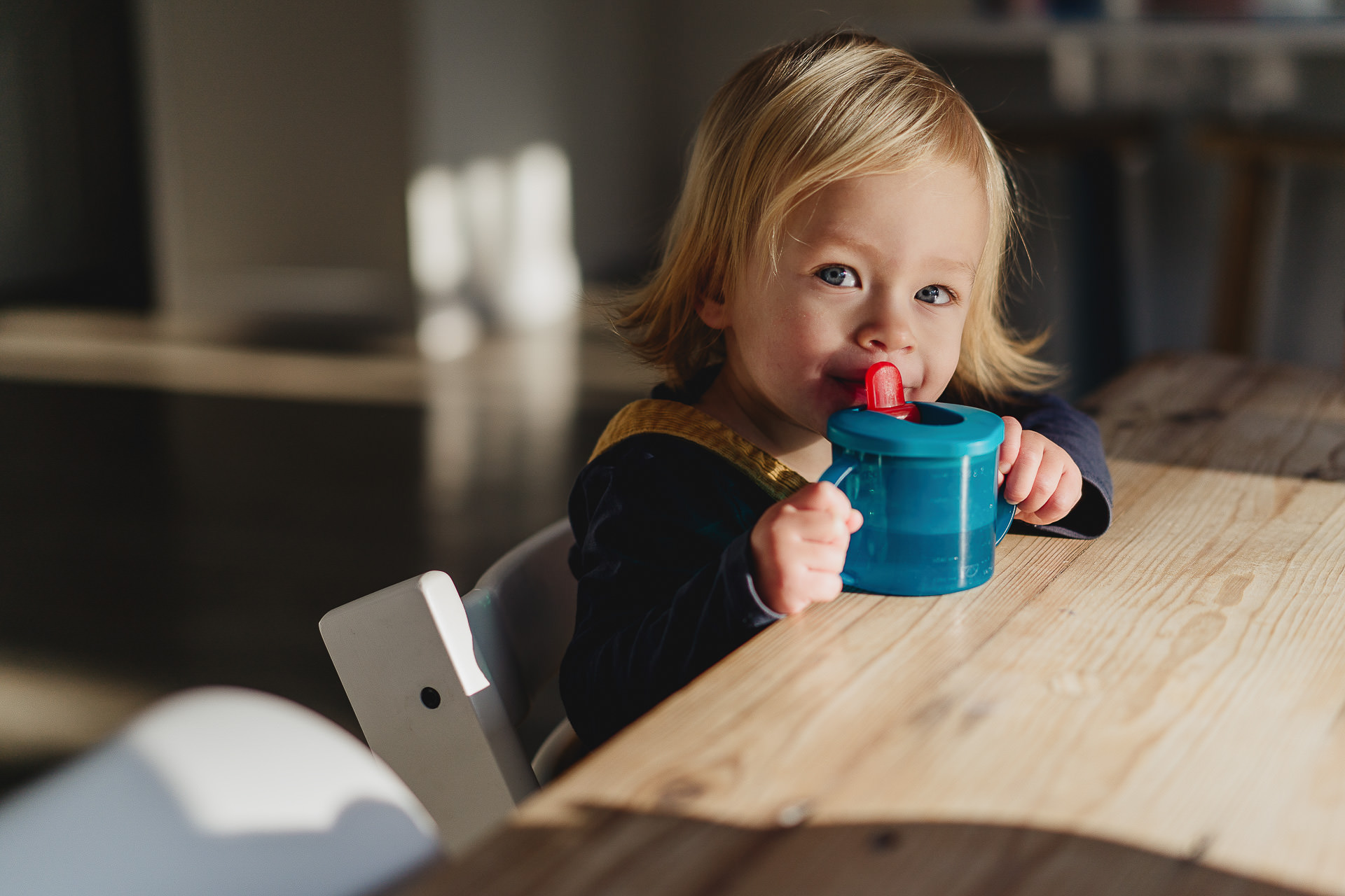 A young girl with a blue sippy cup
