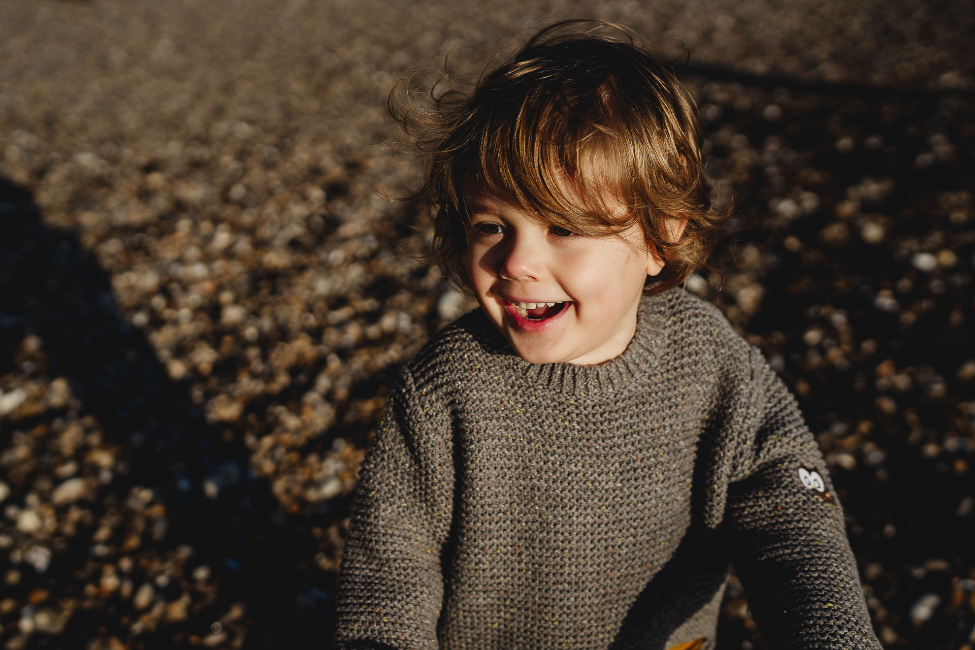 A young boy laughing on a beach