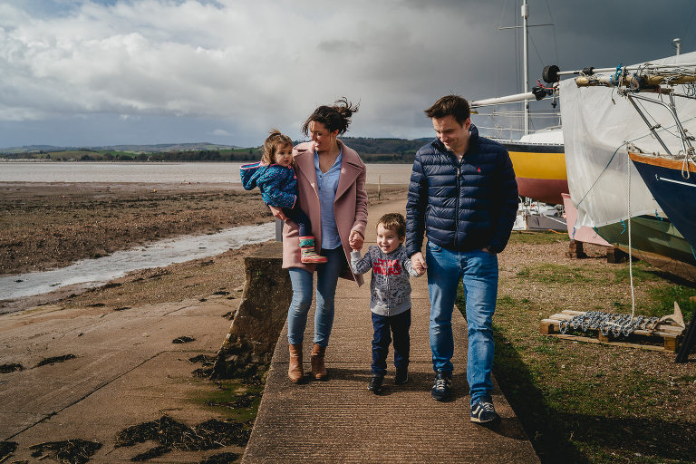 A relaxed photograph of a family walking together at Lympstone harbour