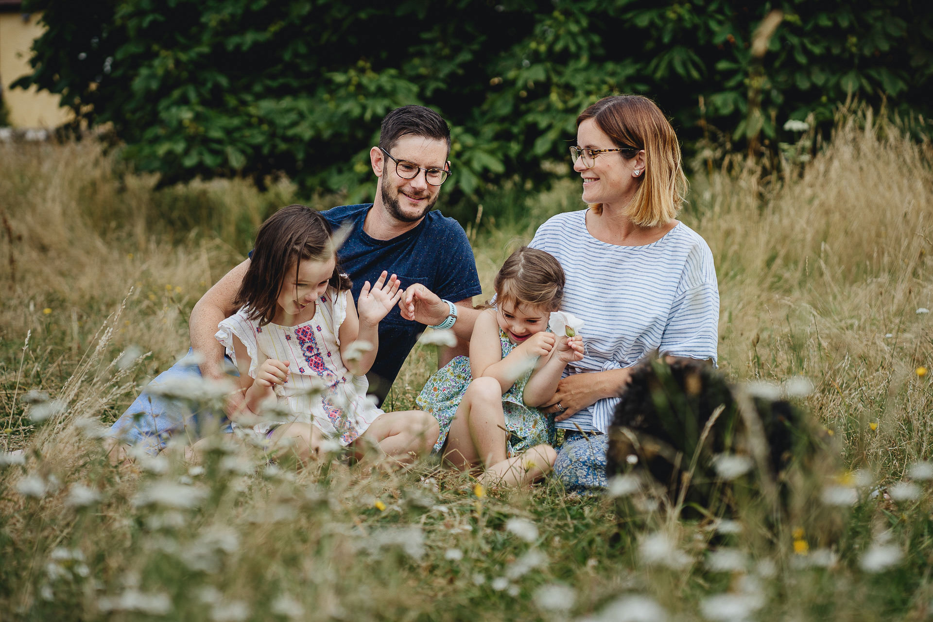A family laughing together in a meadow