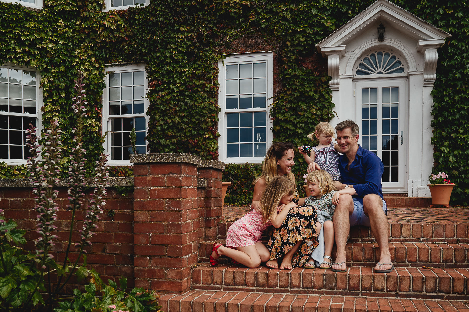A family laughing together on the steps of a house
