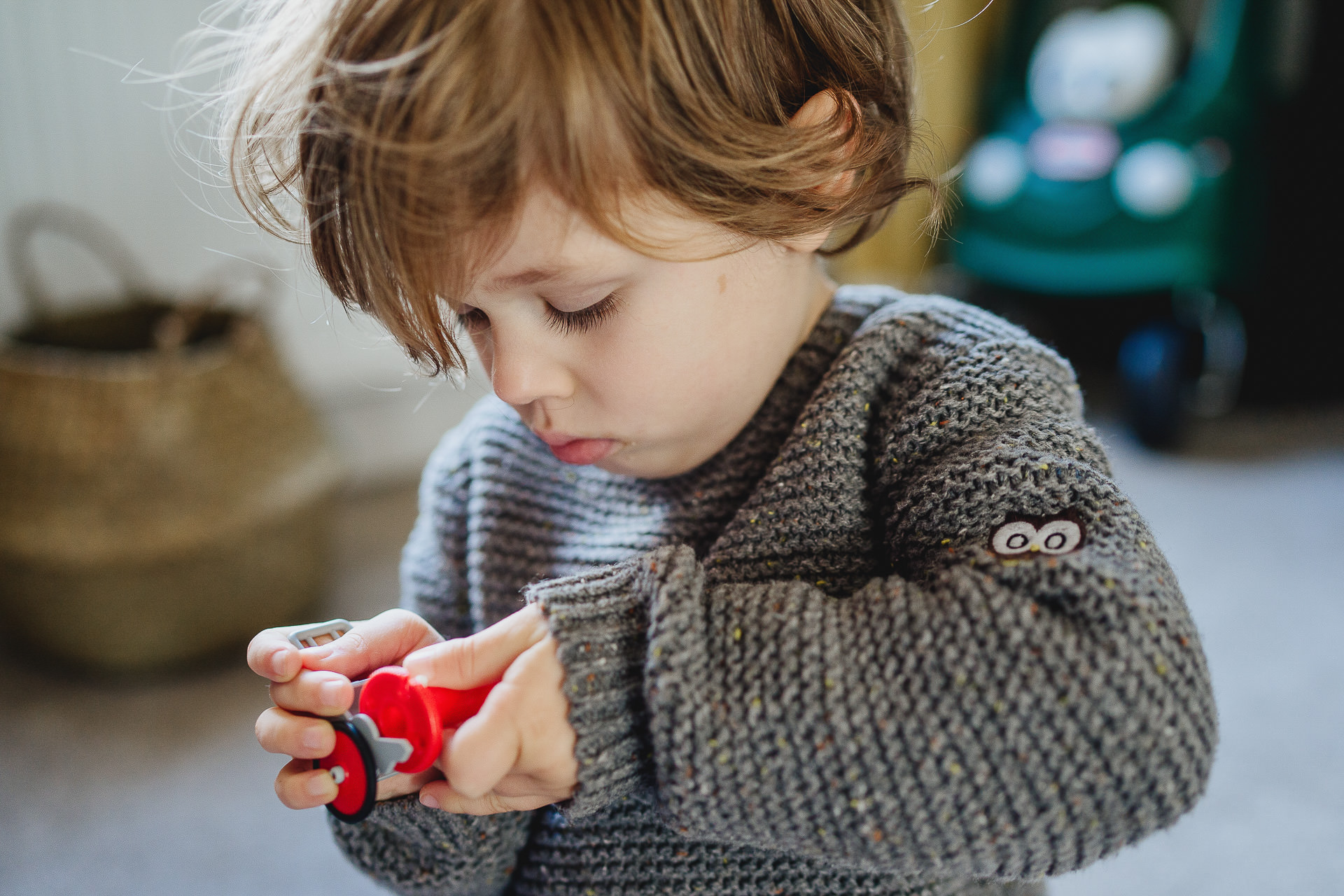 A small boy concentrating on a toy
