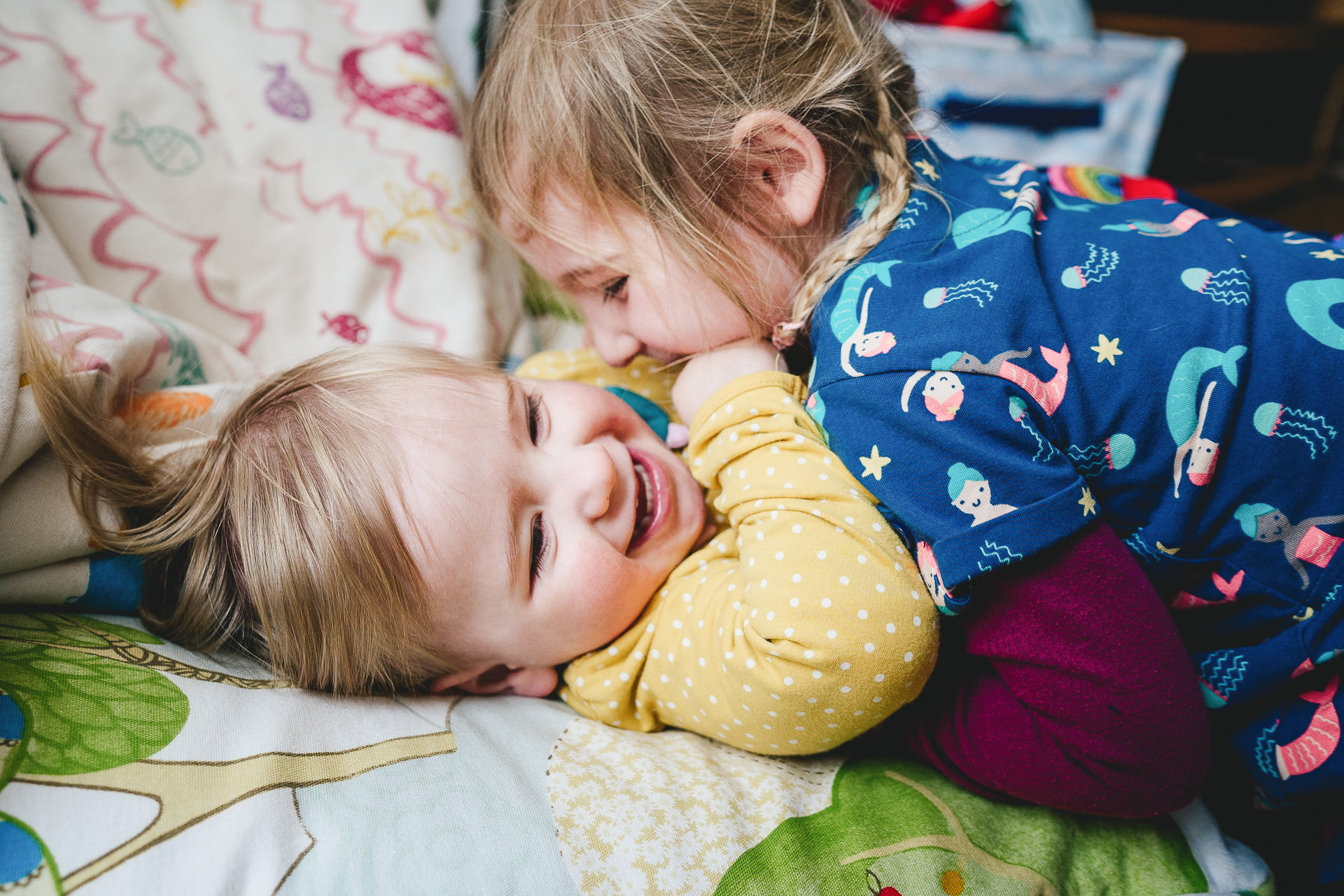 Two young sisters playing together and laughing