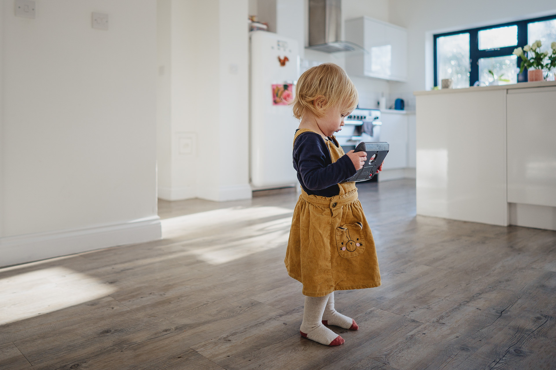 A small girl standing in a large kitchen
