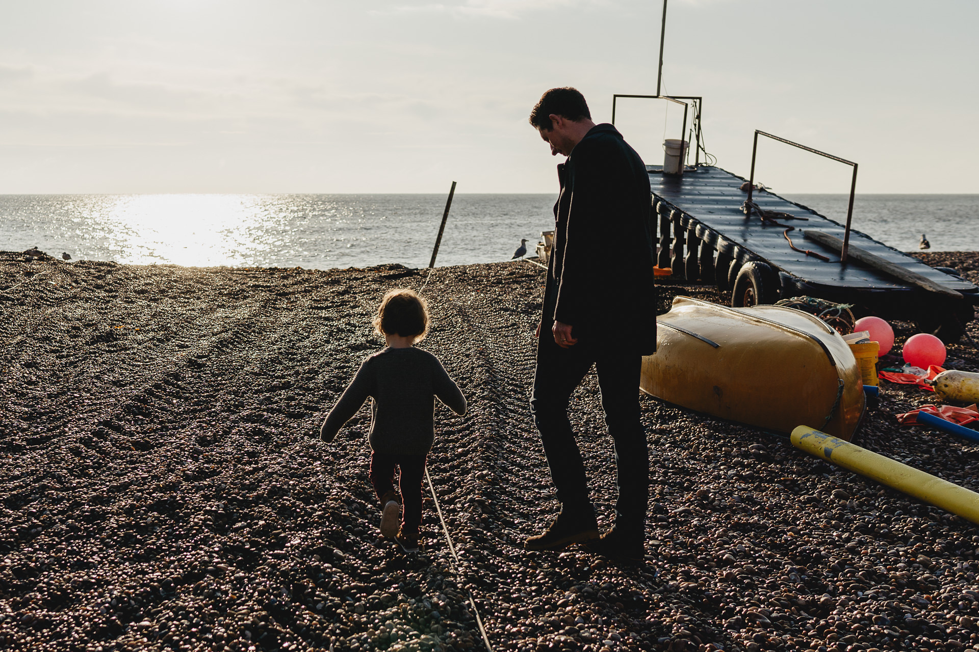 A father and son walking onto the beach