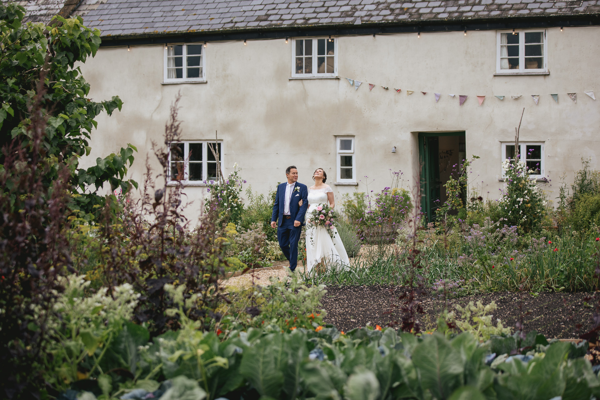 Bride and her father walking through the kitchen garden at River Cottage. 