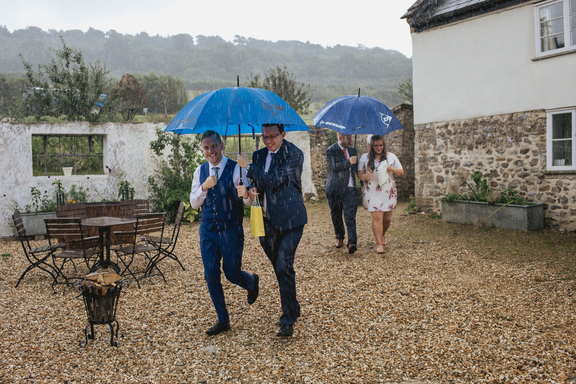 A wet weather wedding with guests running away from the ceremony in the pouring rain