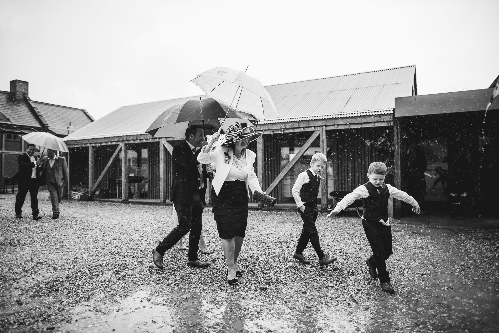 Wedding guests under umbrellas on a rainy wedding day