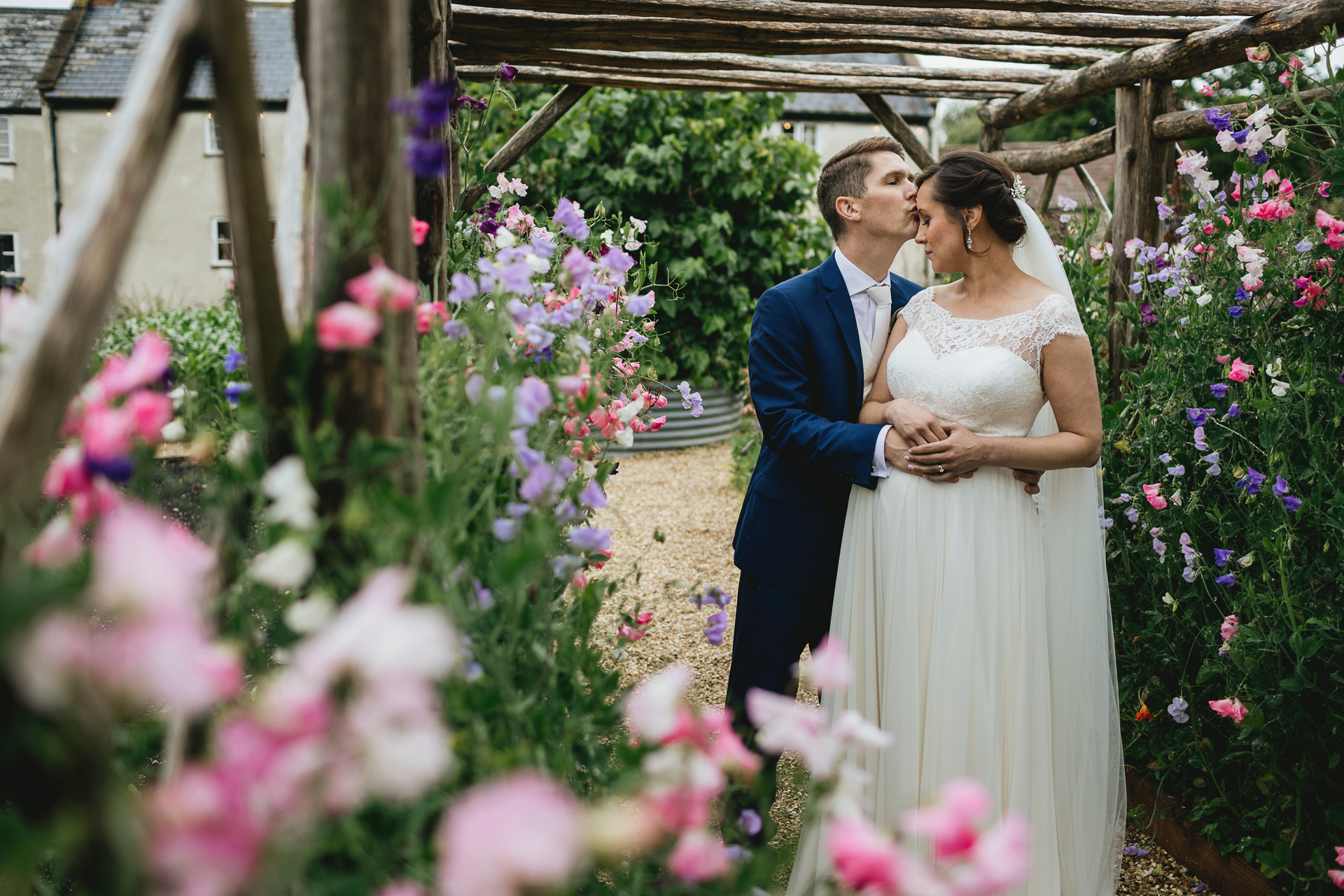 A bride and groom amongst sweet peas in a kitchen garden