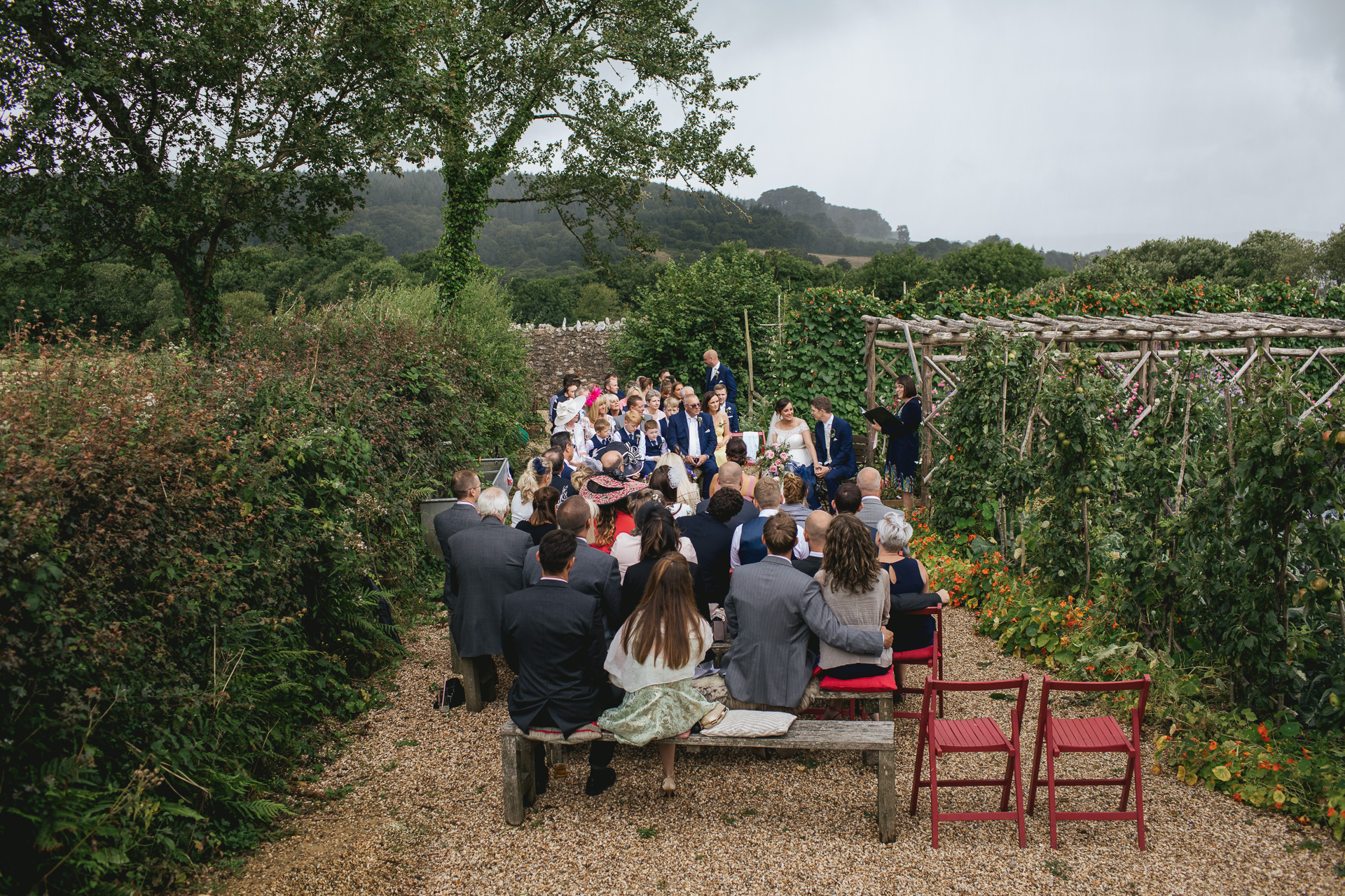 An outdoor wedding ceremony with rain starting to fall