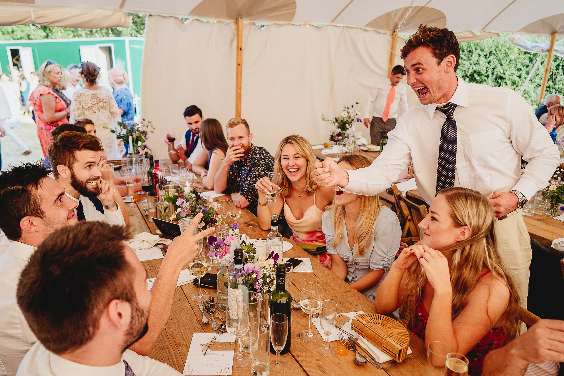 Wedding guests laughing in a marquee