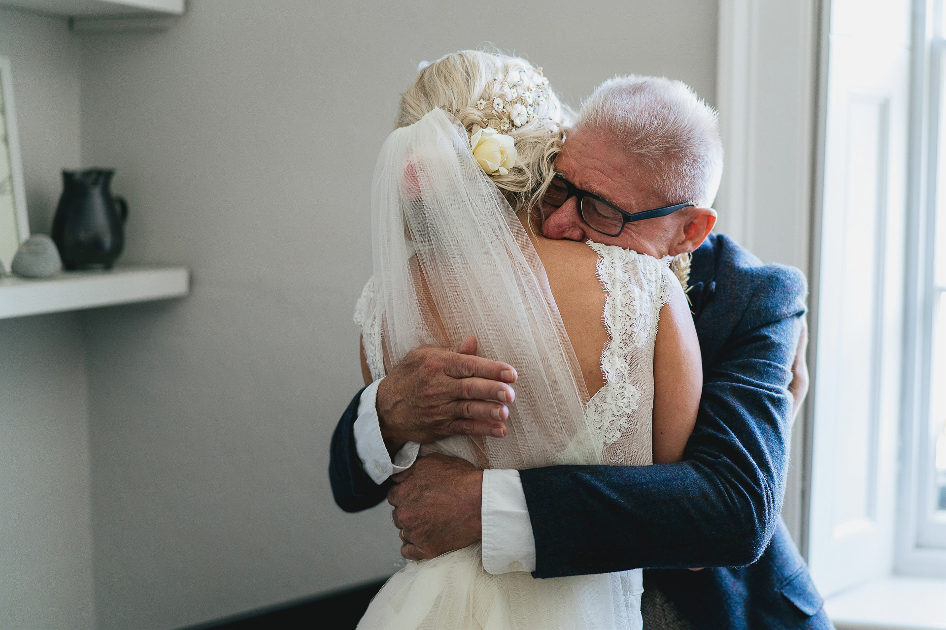 Father cuddling bride in wedding dress