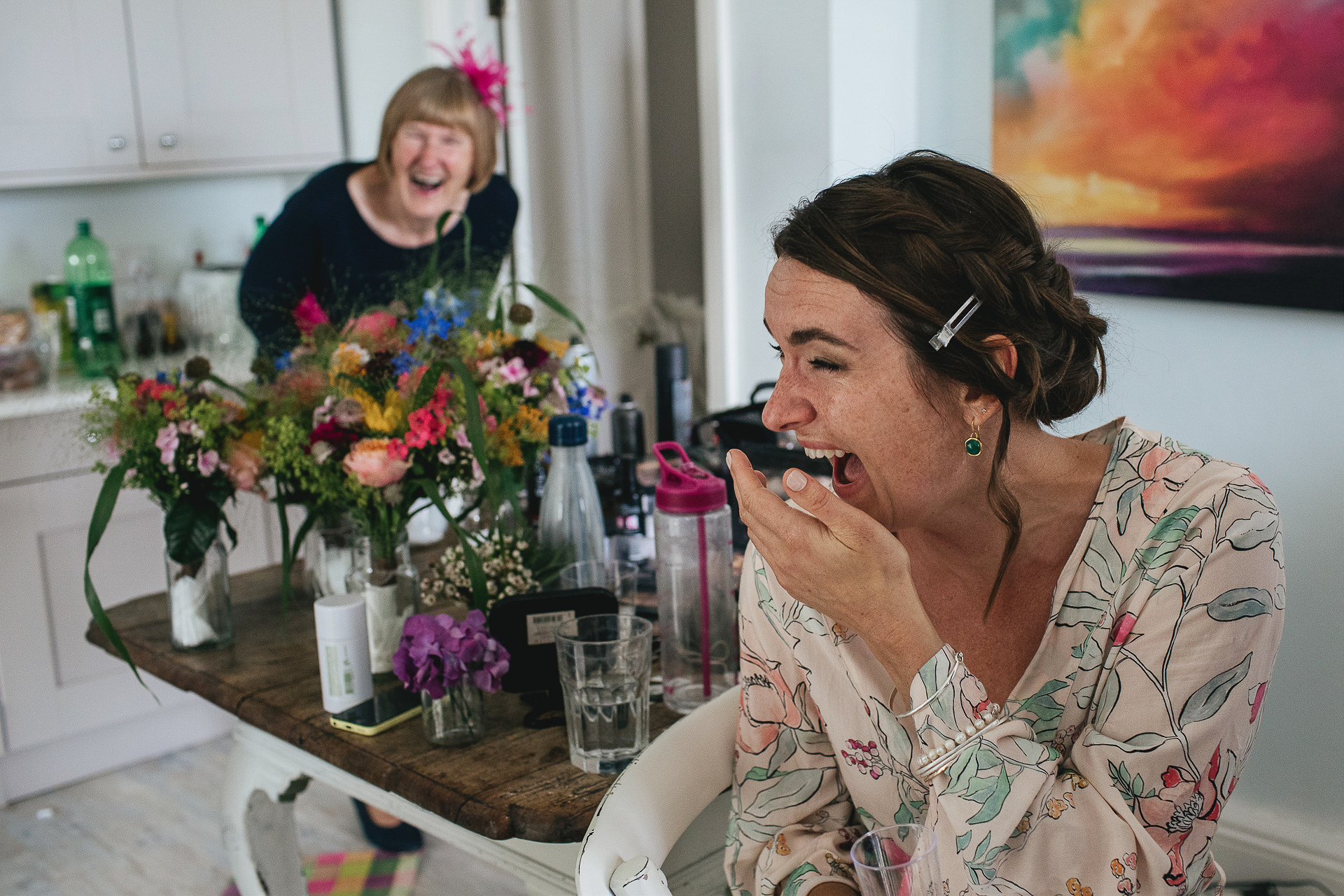 Bride to be laughing with mother during wedding preparations