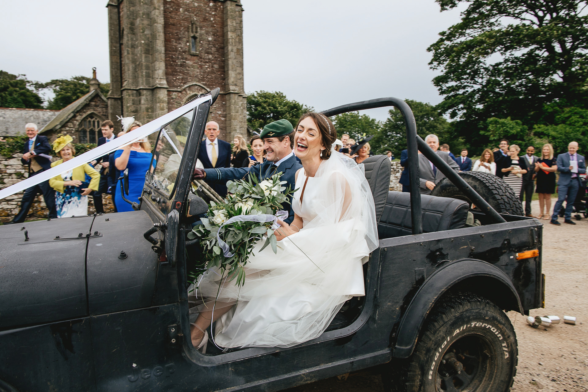 Laughing bride and groom leaving church in a landcover