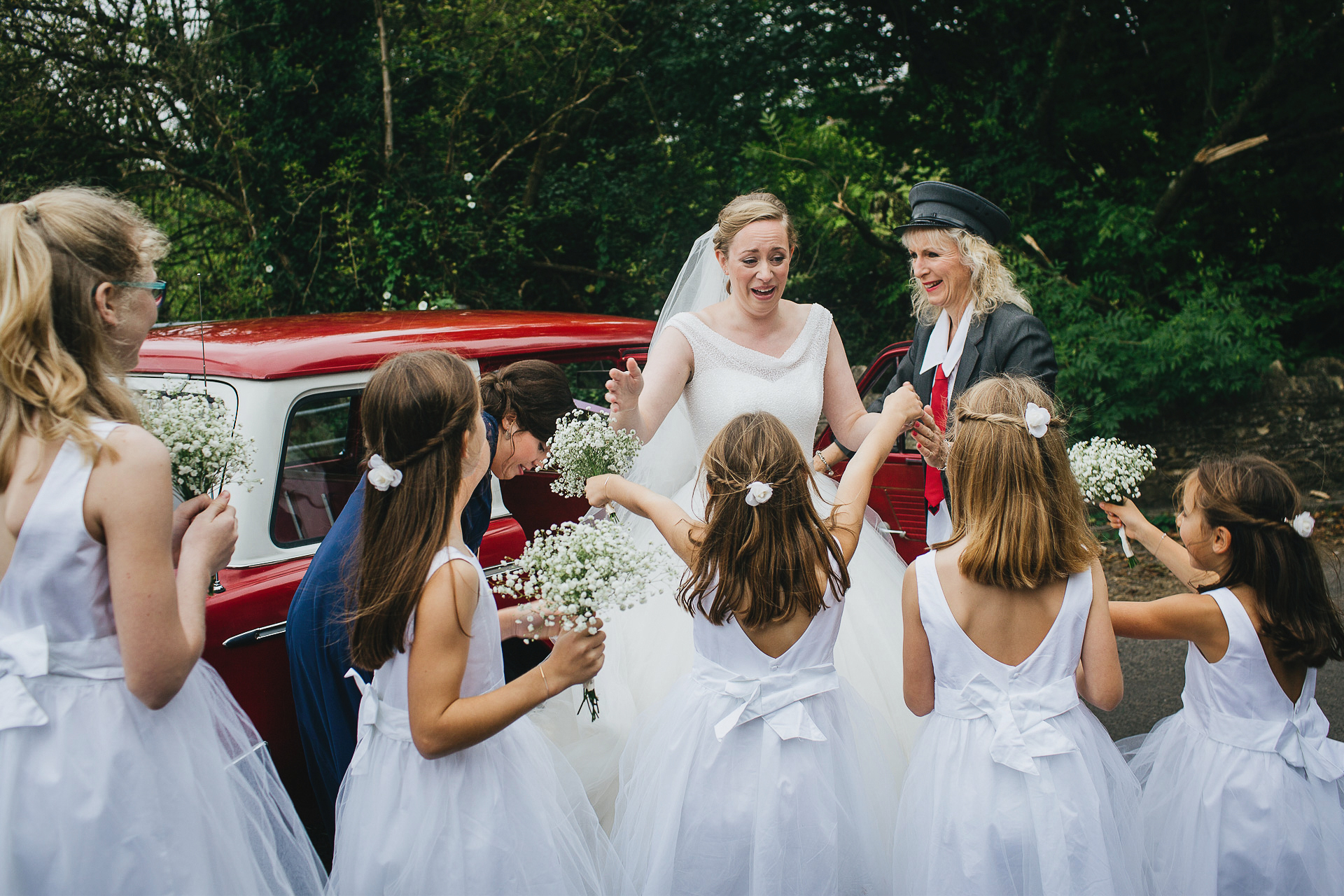 Bride overwhelmed by happiness greeting a crowd of flower girls