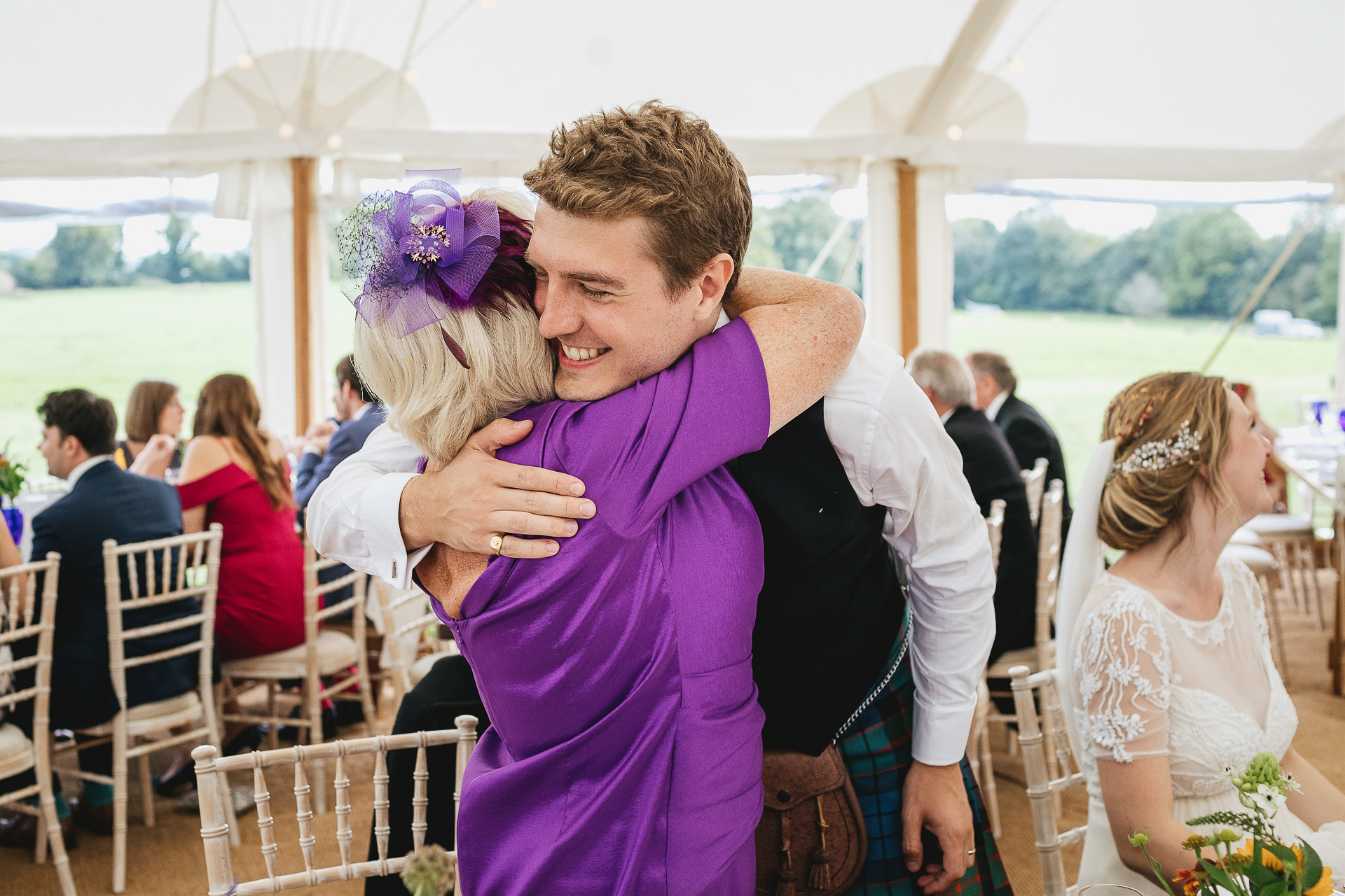 Groom hugging mother in a marquee