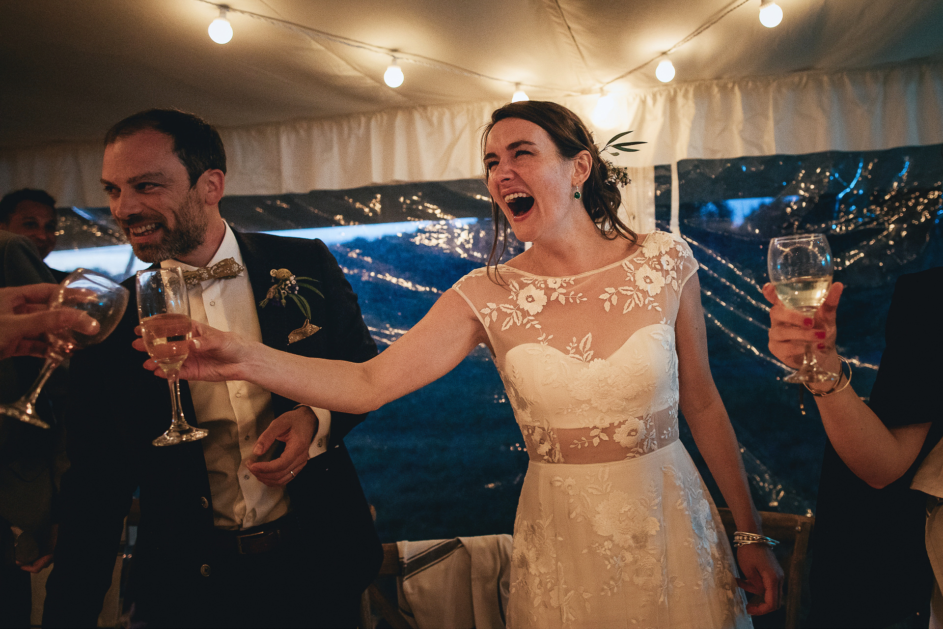 Bride and groom toasting happily in a marquee