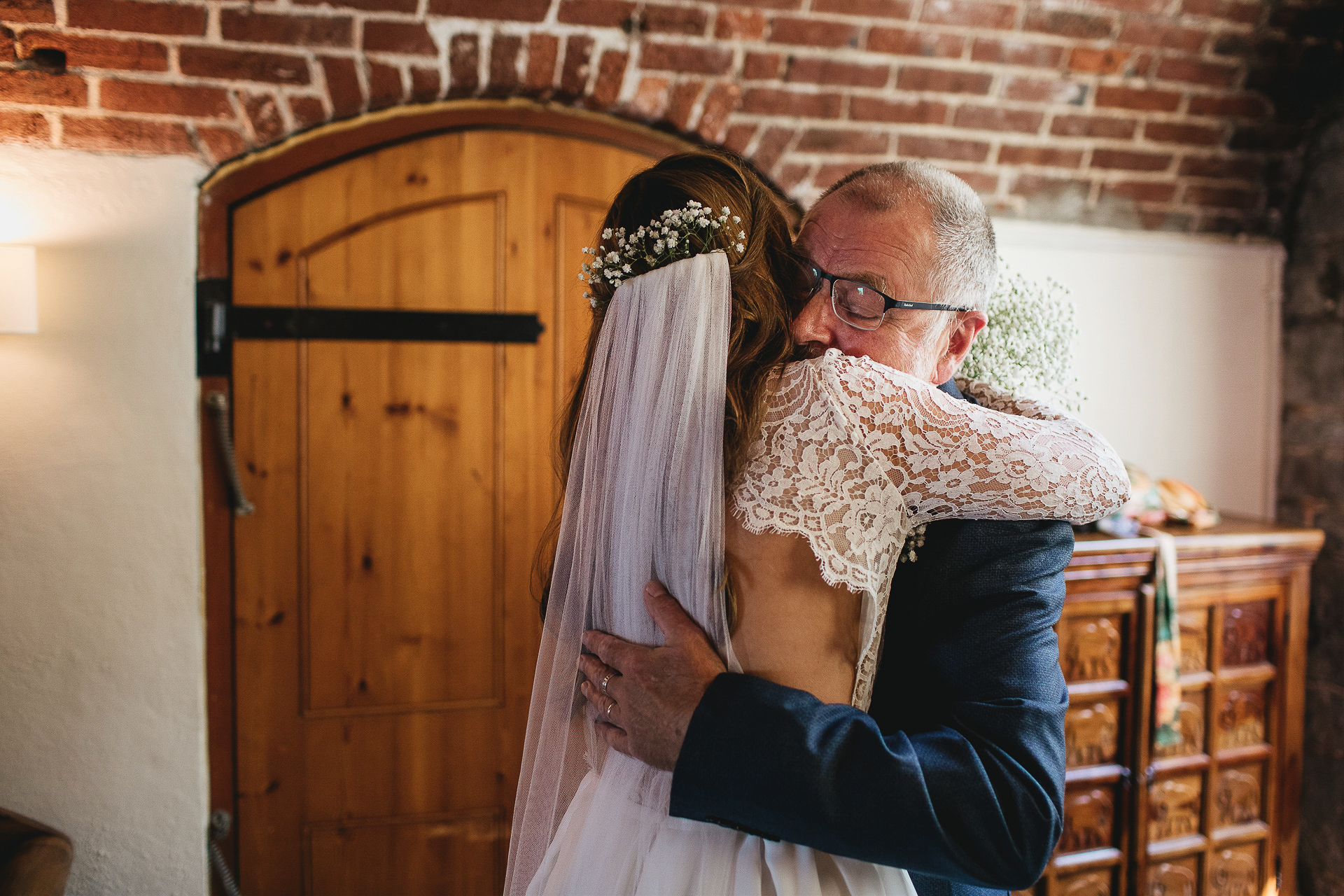 Father hugging bride daughter in wedding dress