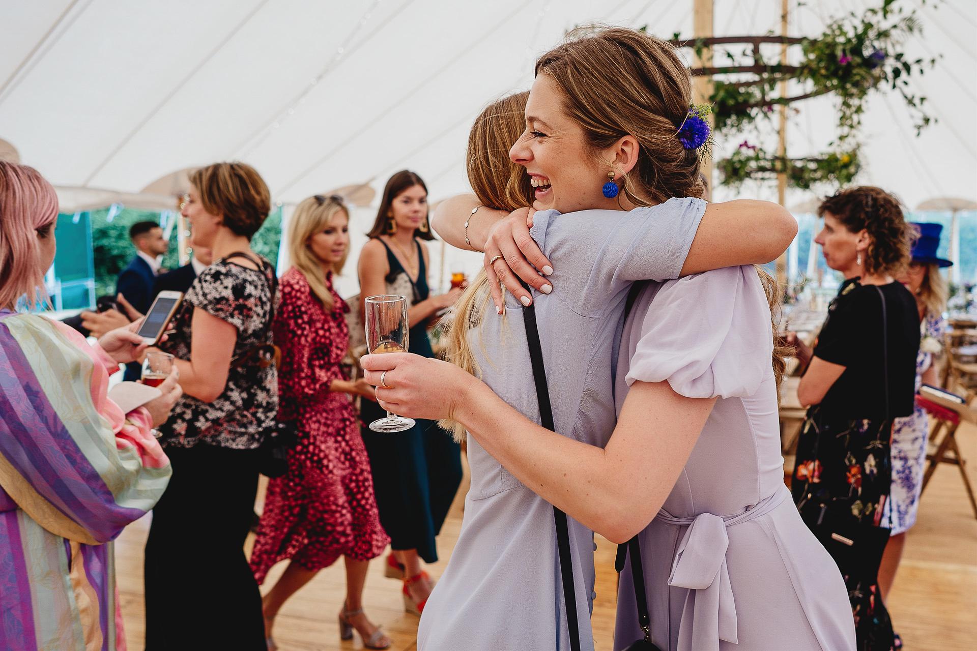 Wedding guests hugging in a marquee