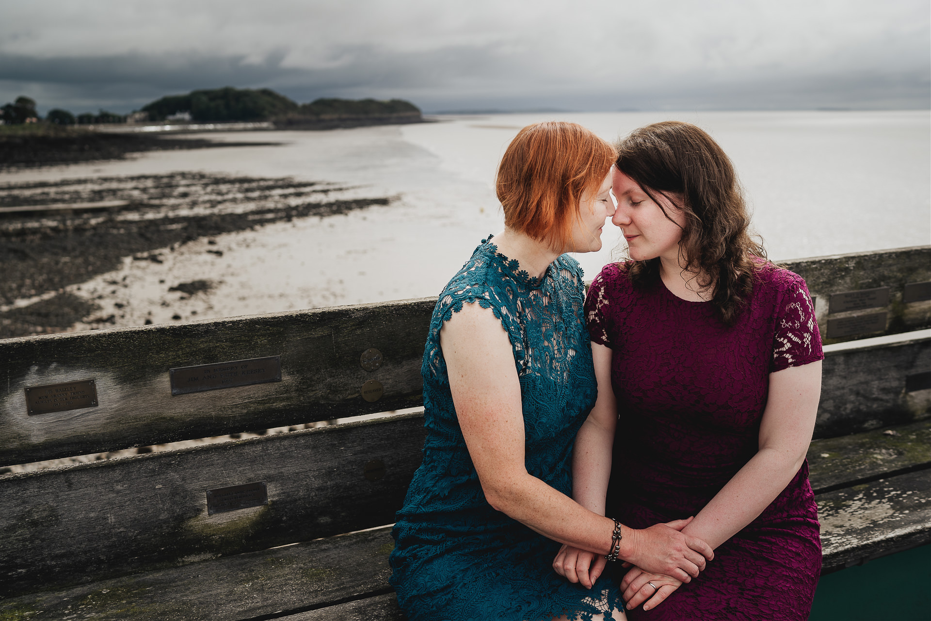 Bride and bride on Clevedon pier with dark clouds in skies above