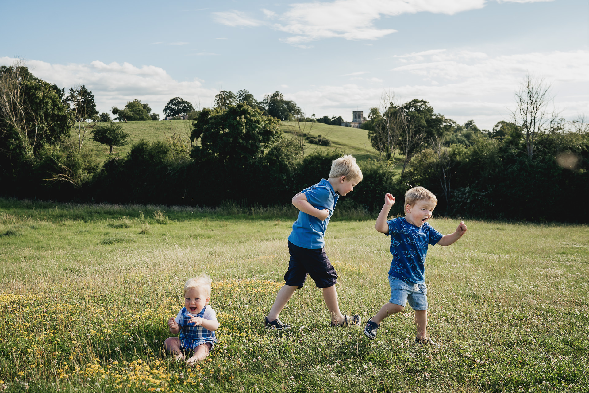 Three children doing funny dancing on a hillside