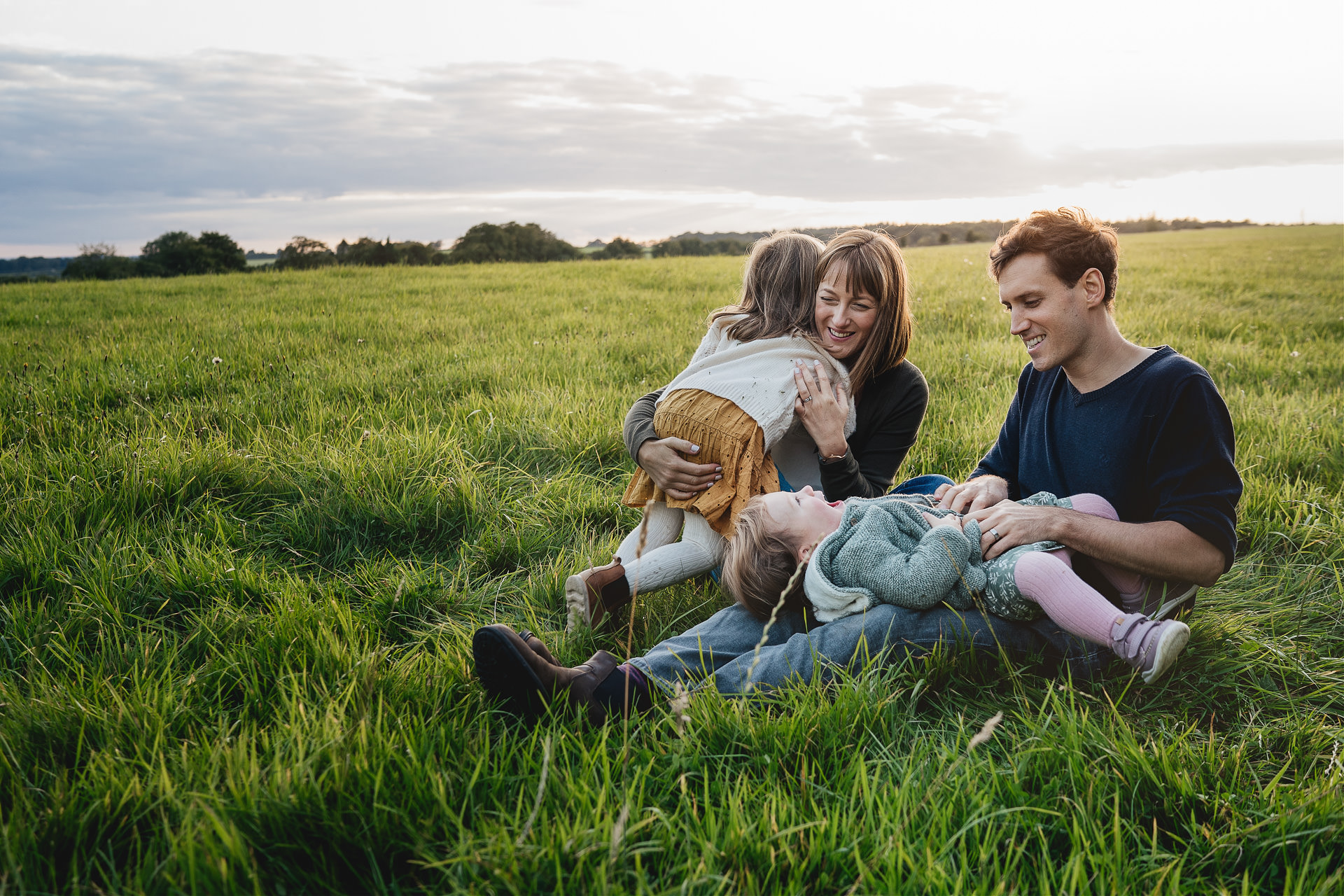 A family cuddling together in a field