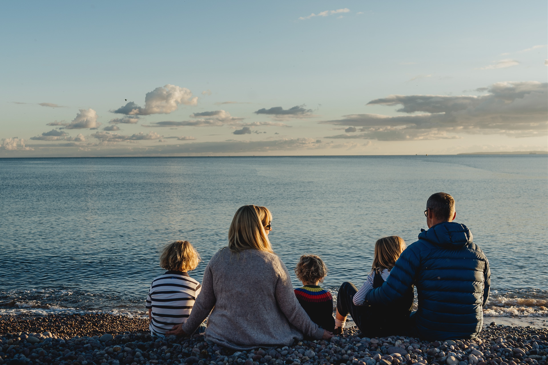 A family sitting together looking at the sea