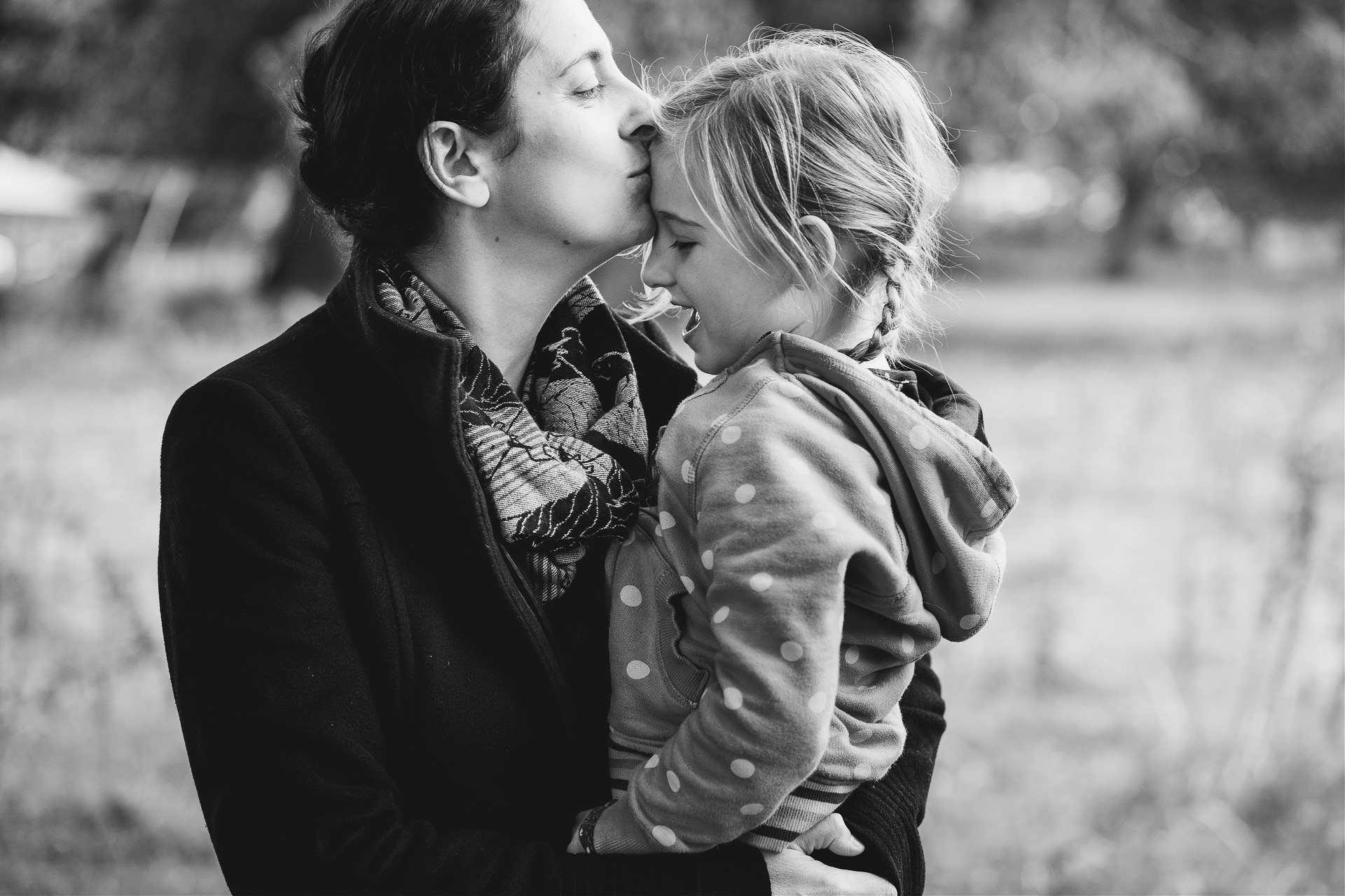 A mother kissing her daughter on the forehead