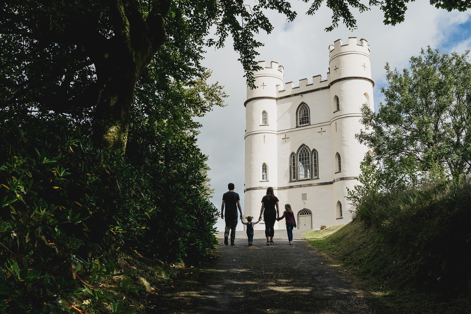 Devon family photography image of a family walking hand in hand towards Haldon Belvedere