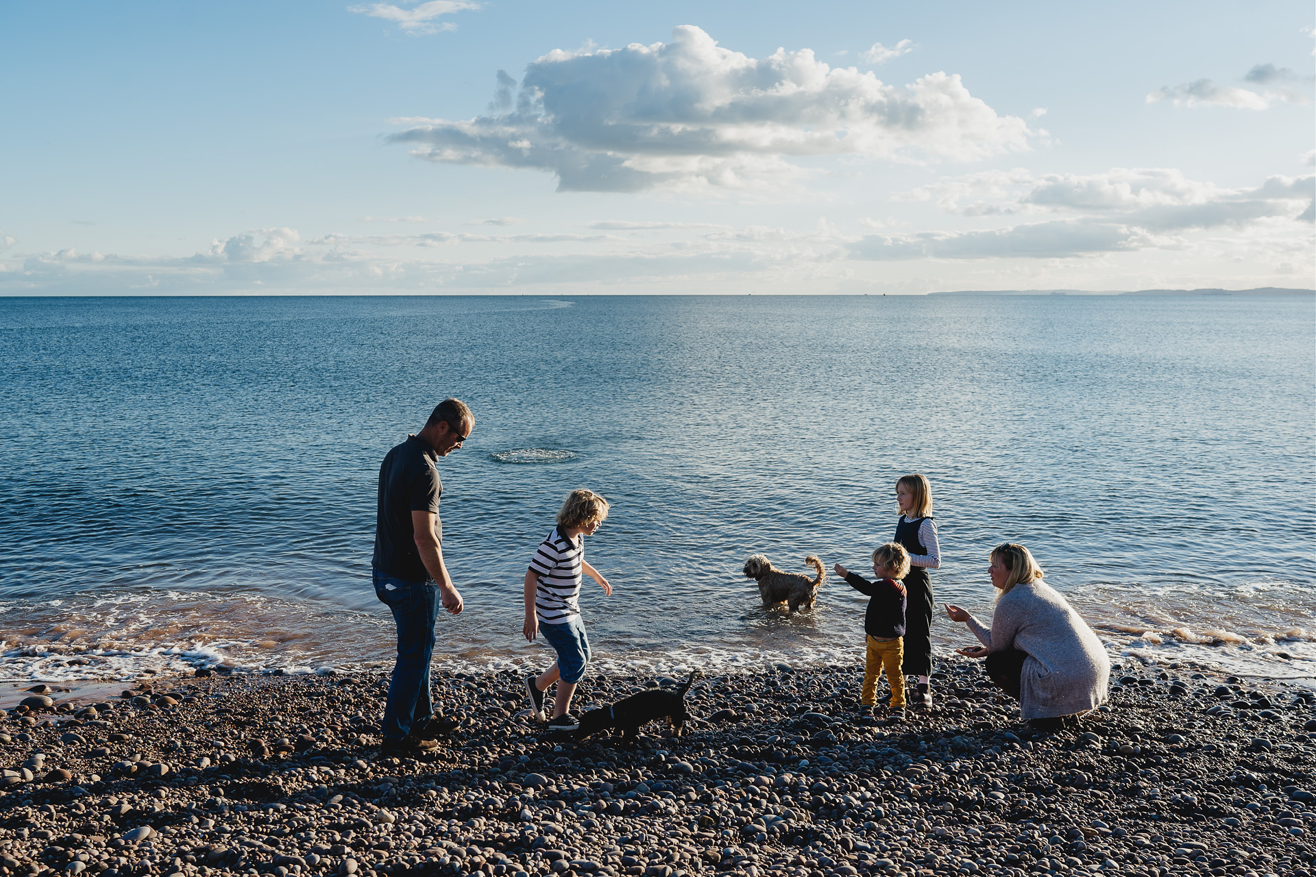 Relaxed photograph of a family playing at the beach together