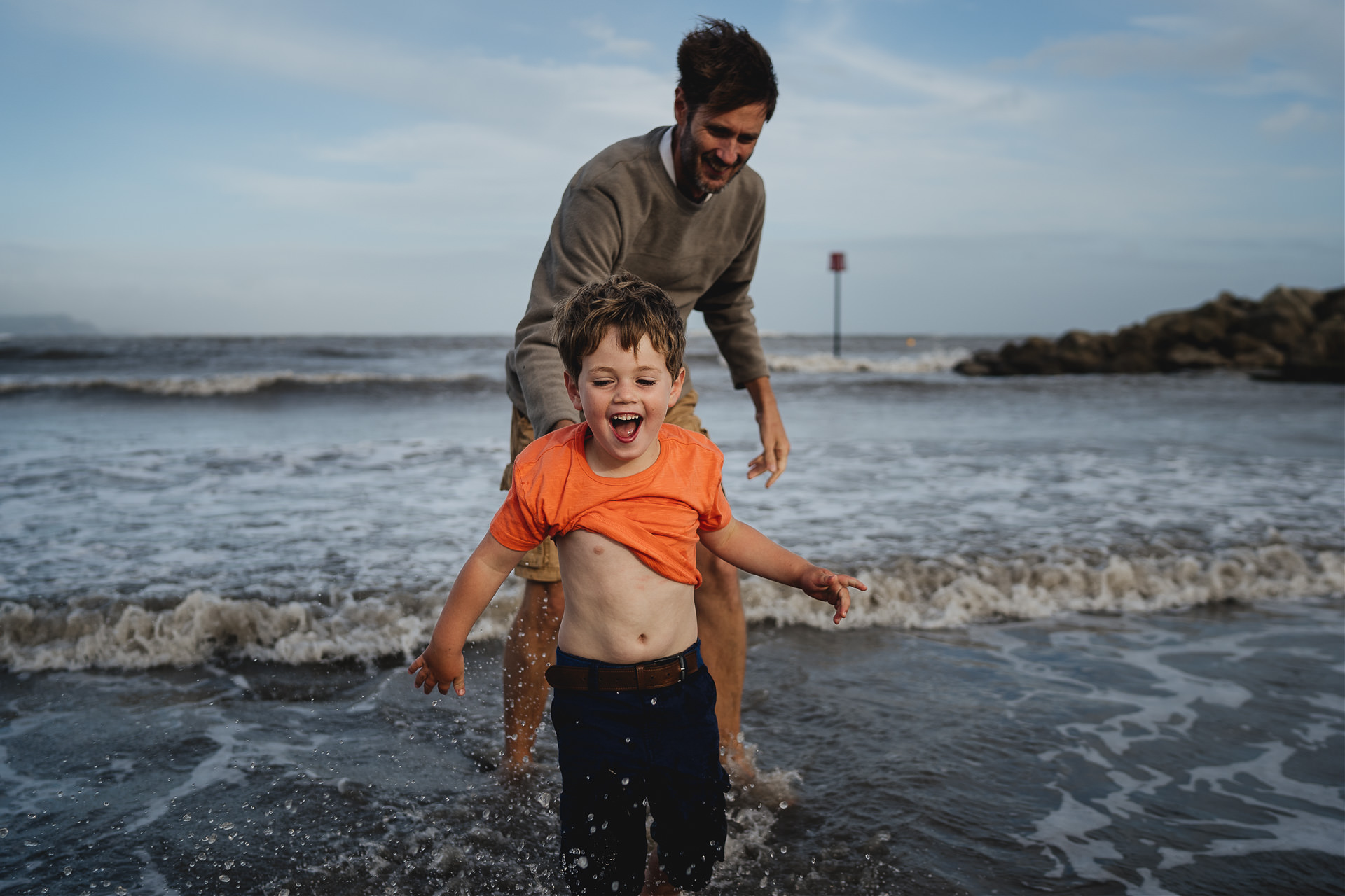 A young boy playing in the sea with his father