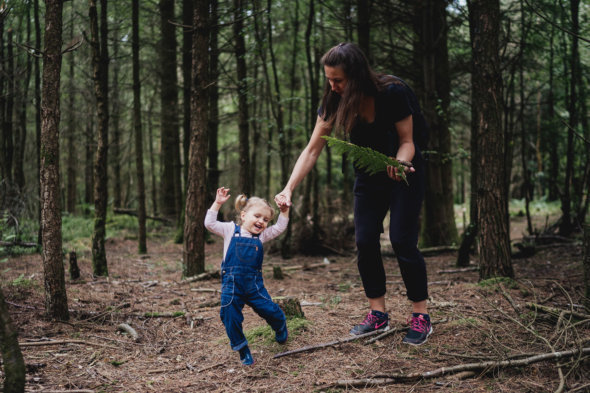 A mother and daughter playing in the woods