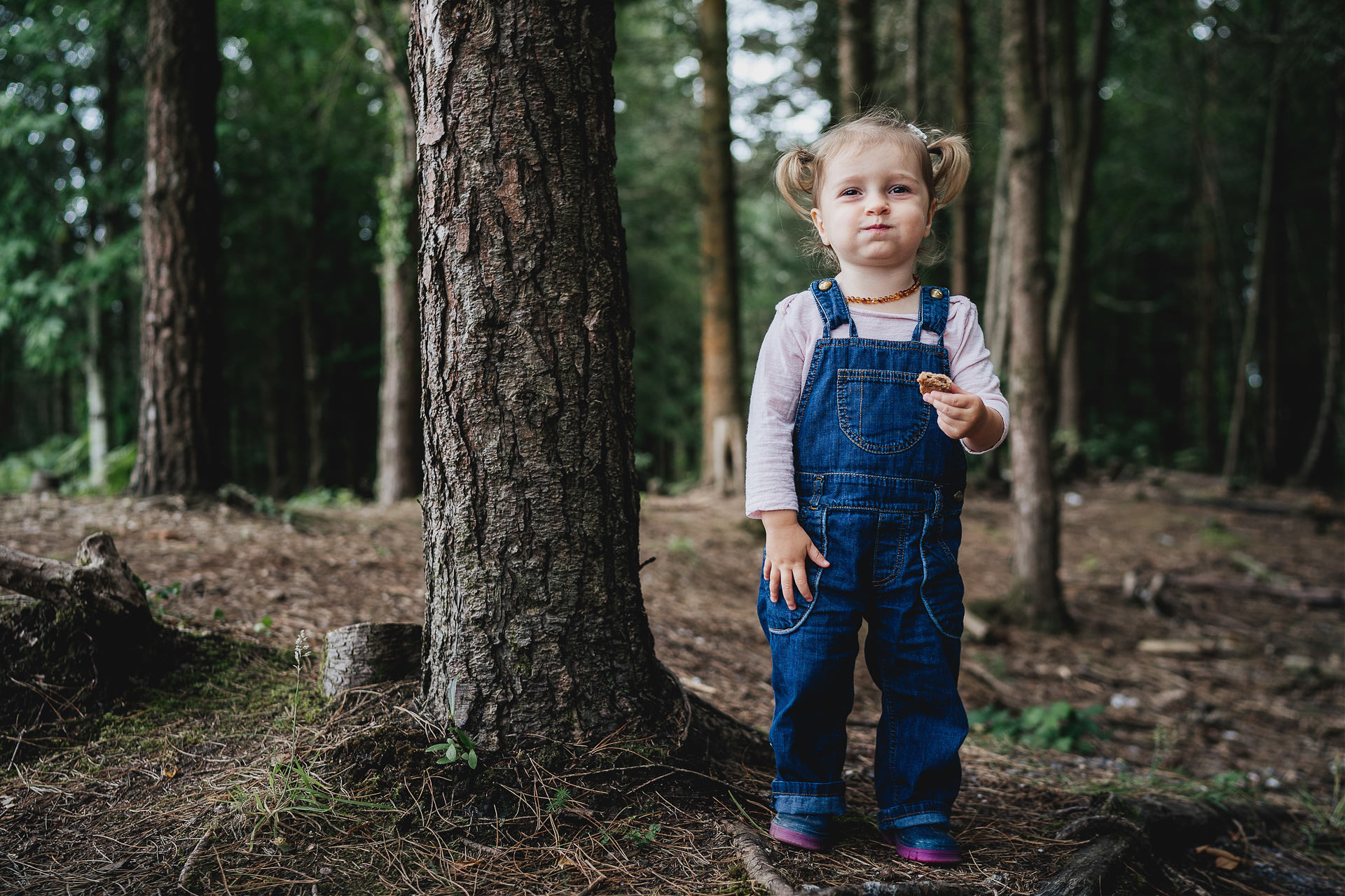Relaxed family portrait of a young girl playing in the woods in Devon