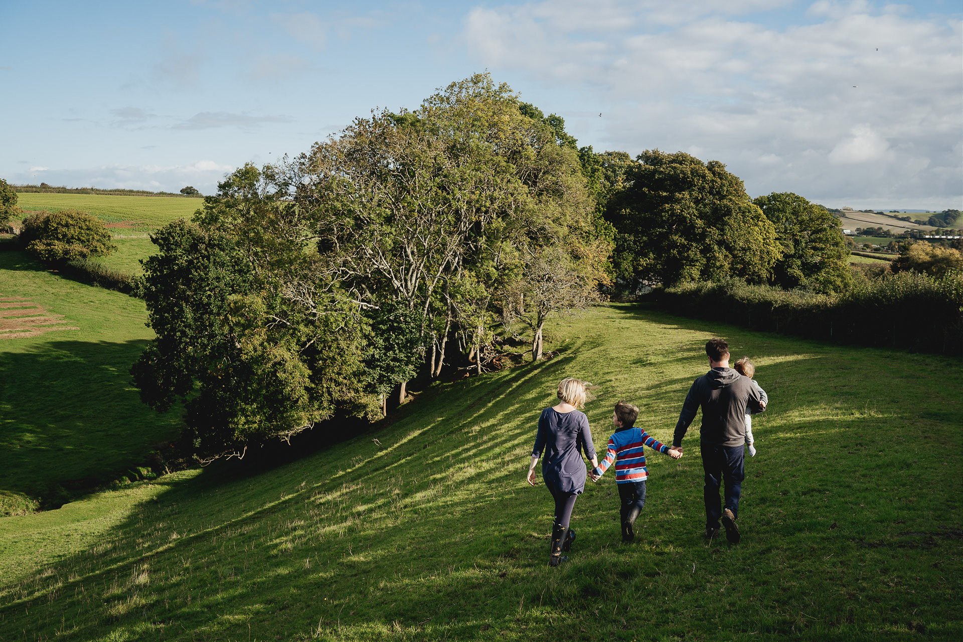 Relaxed photograph of a family walking together over hills