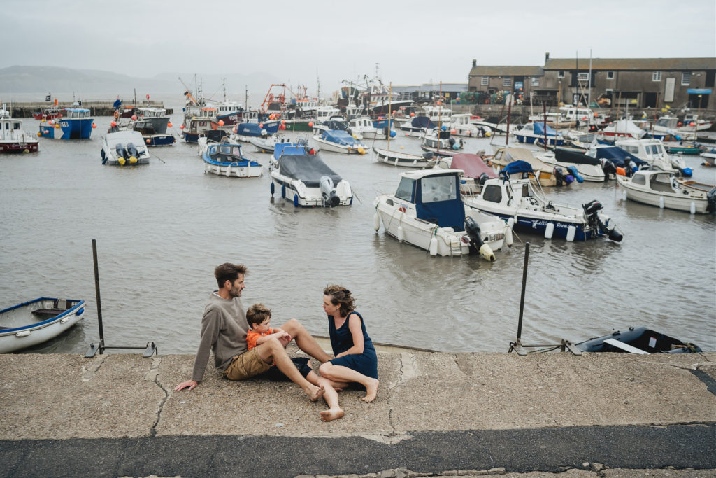 Natural portrait of a family sitting together at Lyme Regis Cobb